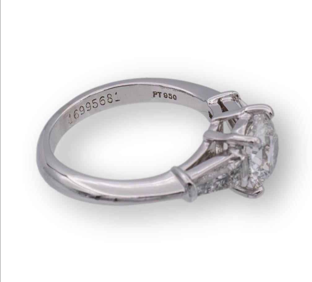 Tiffany & Co. three- stone diamond engagement ring finely crafted in platinum with a round brilliant cut center weighing 1.33 carats F color VS1 clarity flanked by 2 tapered baguette diamond sides weighing 0.44 carats total weight G color VVS