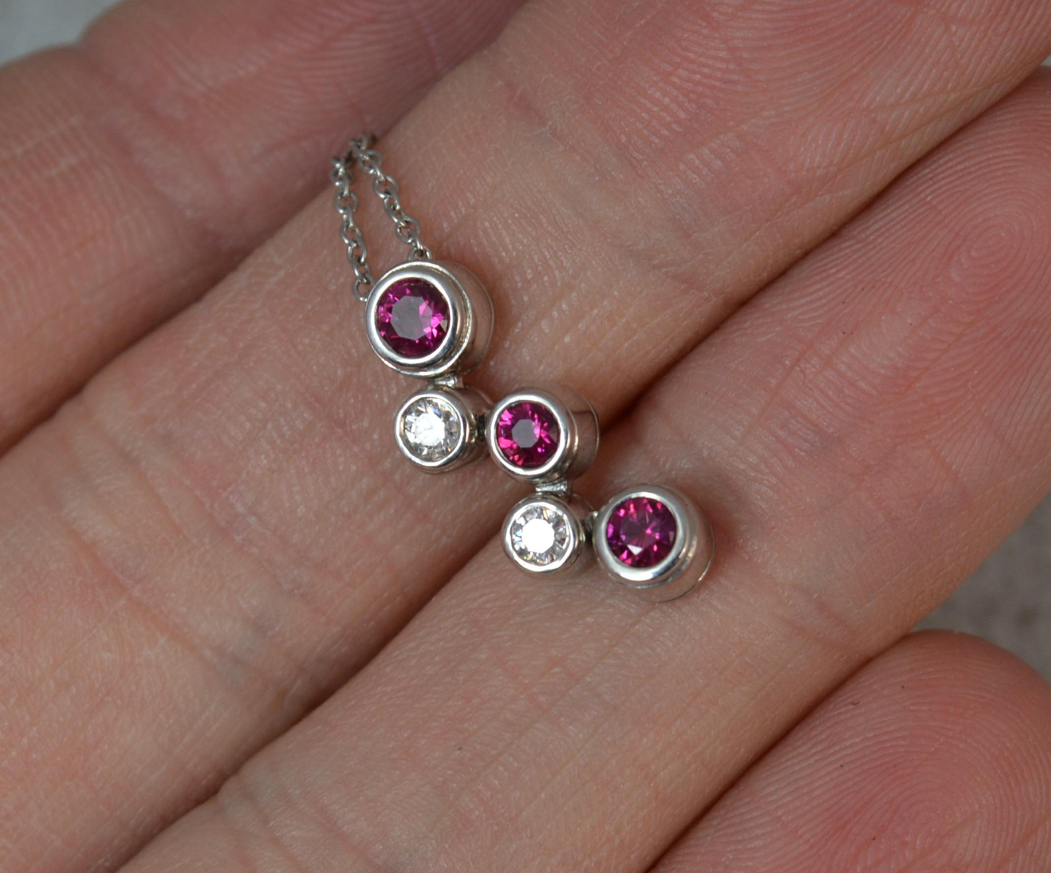 A fantastic TIFFANY & CO designer pendant.
950 grade platinum pendant and chain.
Designed with a five stone bezel set drop bubble like pendant drop. Three rubies and two diamonds. Stunning quality. Complete with fine links.
No longer available new