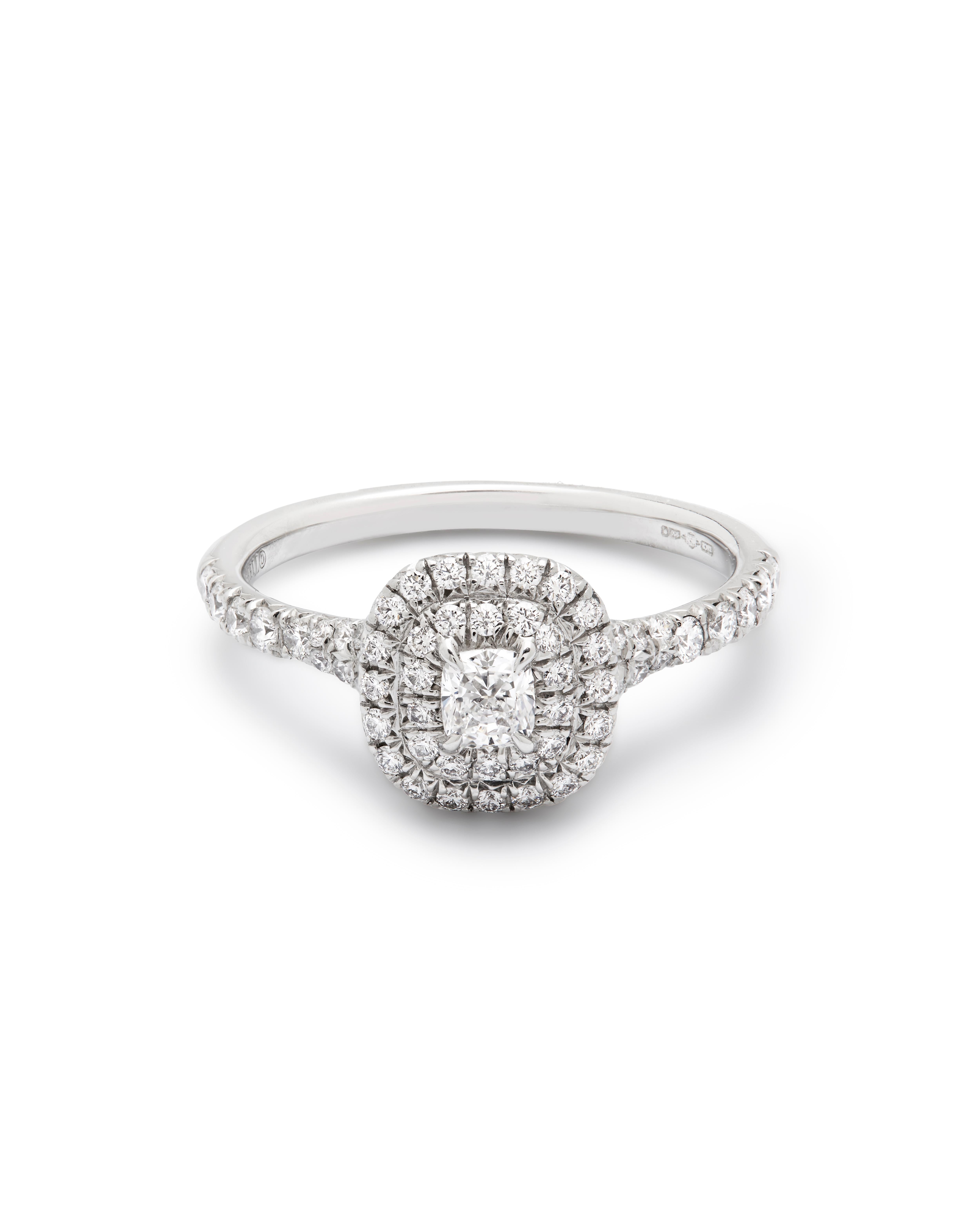 Tiffany & Co. - ein Soleste-Doppelhalo-Diamantenverlobungsring.

Dieser schöne Ring ist in Platin gefasst und strahlt von jeder Seite Licht aus. 

Mit einem zentralen Diamanten im Kissenschliff von 0,20 ct und zwei Reihen von Diamantenhalos mit