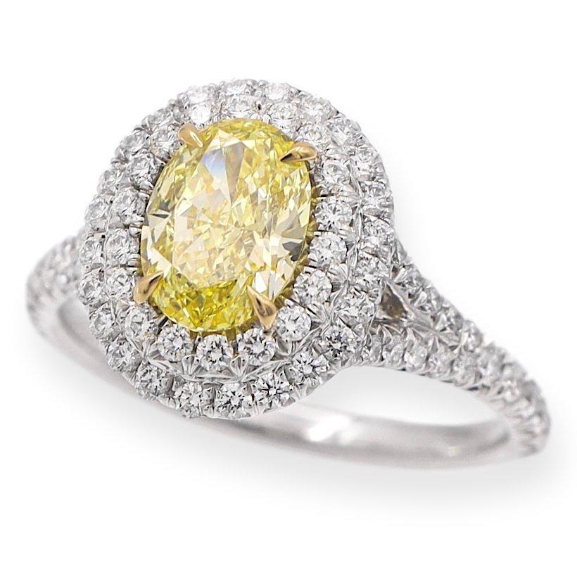 Tiffany & Co. Fancy Yellow engagement ring from the Soleste collection featuring a 1.04 carat oval center ,Fancy Intense Yellow VVS2 clarity finely crafted in platinum, accented by a double row halo and split shank design with round brilliant cut