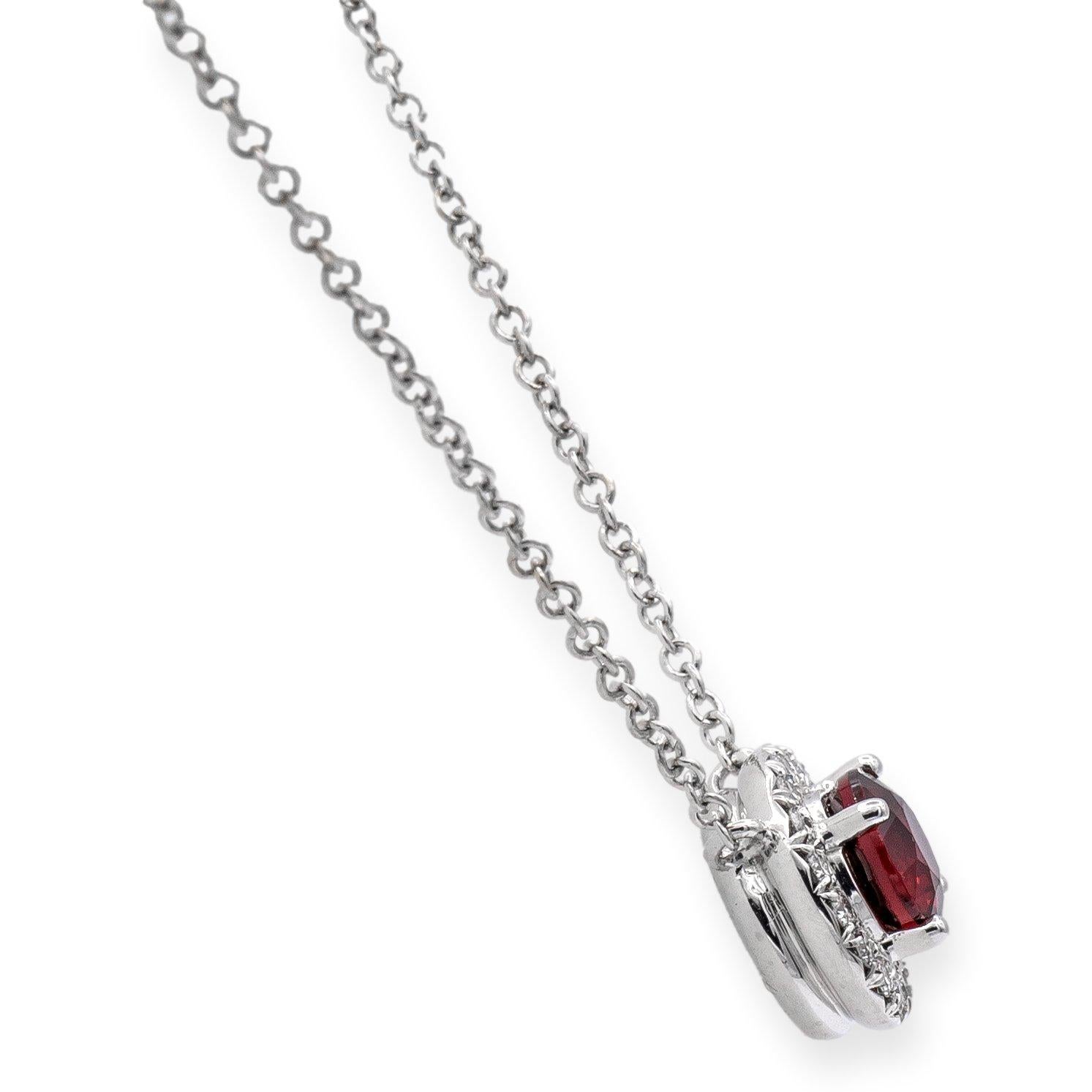 Tiffany & Co. ruby and diamond Soleste stationary pendant necklace finely crafted in platinum featuring one round faceted ruby, weighing .40 carats, that is surrounded by a halo of dazzling round brilliant cut diamonds. The diamonds weigh .09 carats