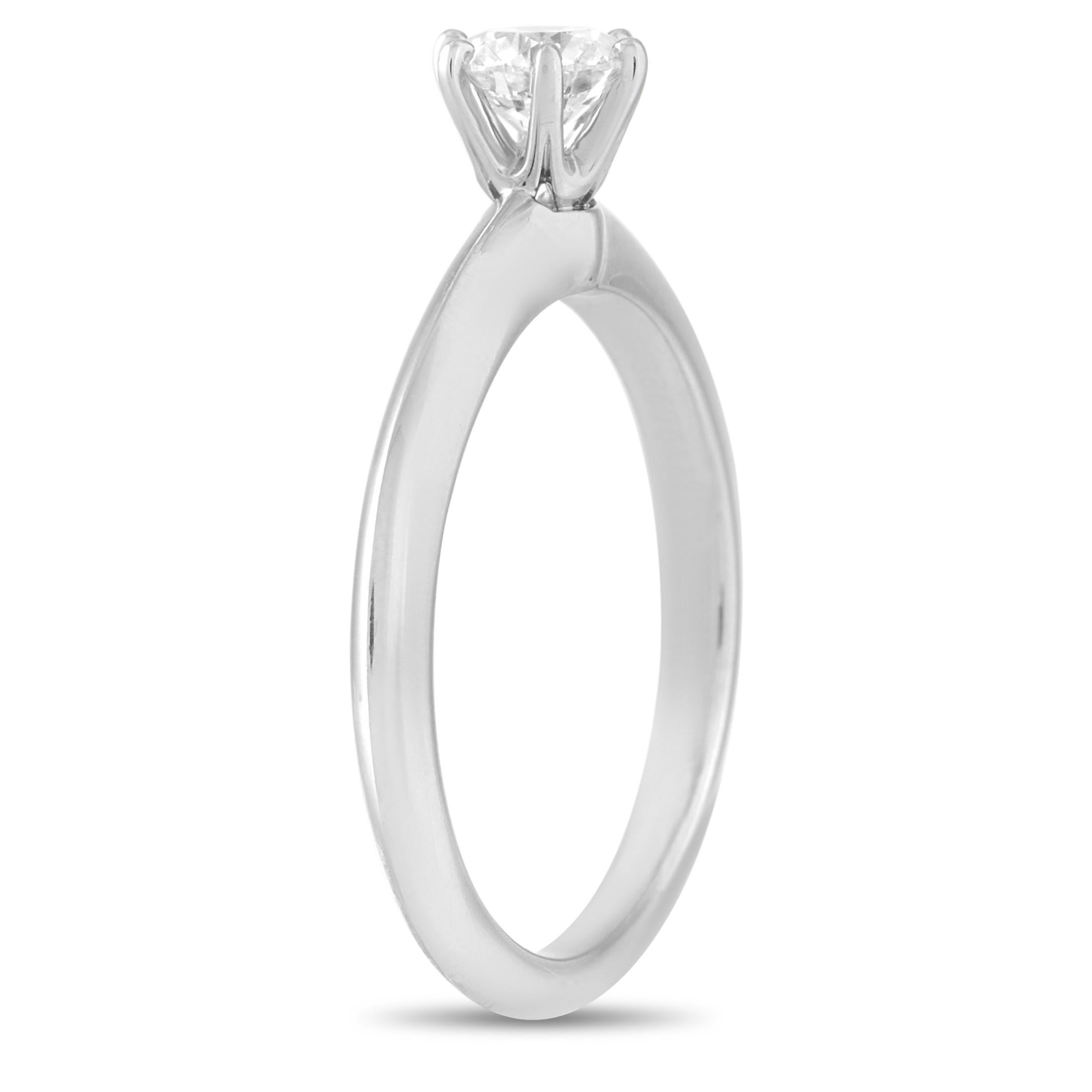 This classic Tiffany & Co. Platinum Solitaire 0.40 ct Diamond Engagement Ring is a timeless piece. The simple band is made with platinum and highlights a solitary 0.40 carat round-cut diamond of G color and VS1 clarity. The ring weighs a total of