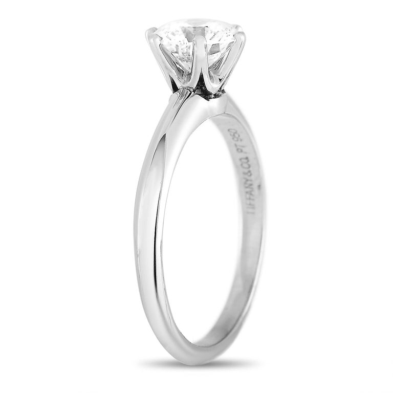 The Tiffany & Co Solitaire Platinum engagement ring is an exceptional piece of jewelry. It’s crafted from platinum and embellished with a 1.07 carat sparkling round brilliant cut diamond stone. It features E color and VVS2 clarity. The ring weighs