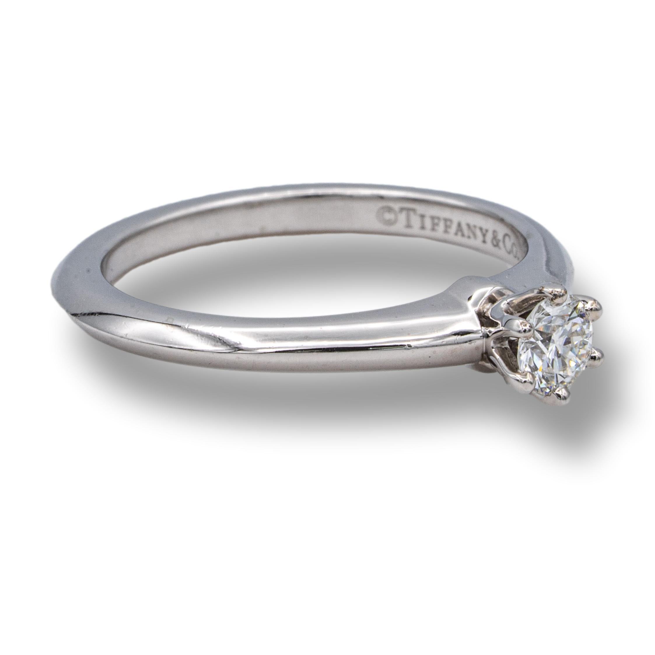 Tiffany & Co. Solitaire engagement ring with a round brilliant cut diamond center weighing 0.23 carats I color VVS1 clarity. Fully Hallmarked and diamond is inscribed.

RING SPECIFICATIONS:
Brand: Tiffany & Co.
Hallmarks: Tiffany & Co. PT950