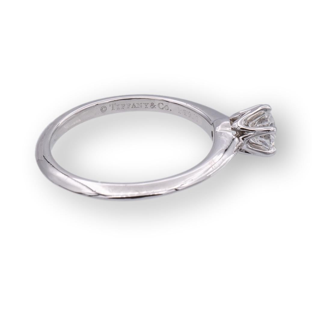 Vintage Tiffany & Co. solitaire engagement ring finely crafted in platinum featuring a round brilliant cut diamond center set in a 6 prong setting weighing 0.42 carats F color VS1 clarity. Fully Hallmarked with logo, serial number and metal