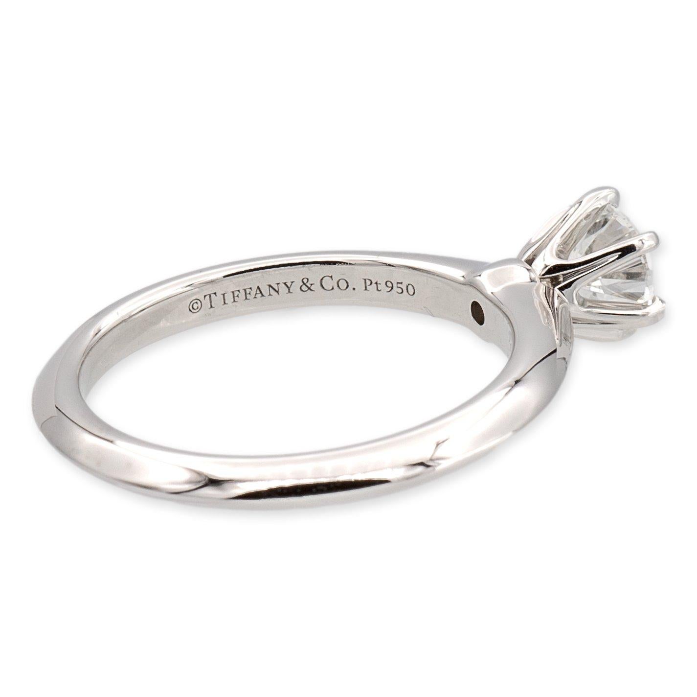 Tiffany & Co. classic solitaire engagement ring finely crafted in platinum featuring a round brilliant cut diamond center set in a 6 prong setting weighing 0.60 carats H color VS1 clarity. This diamond has excellent cut, polish and symmetry. Fully