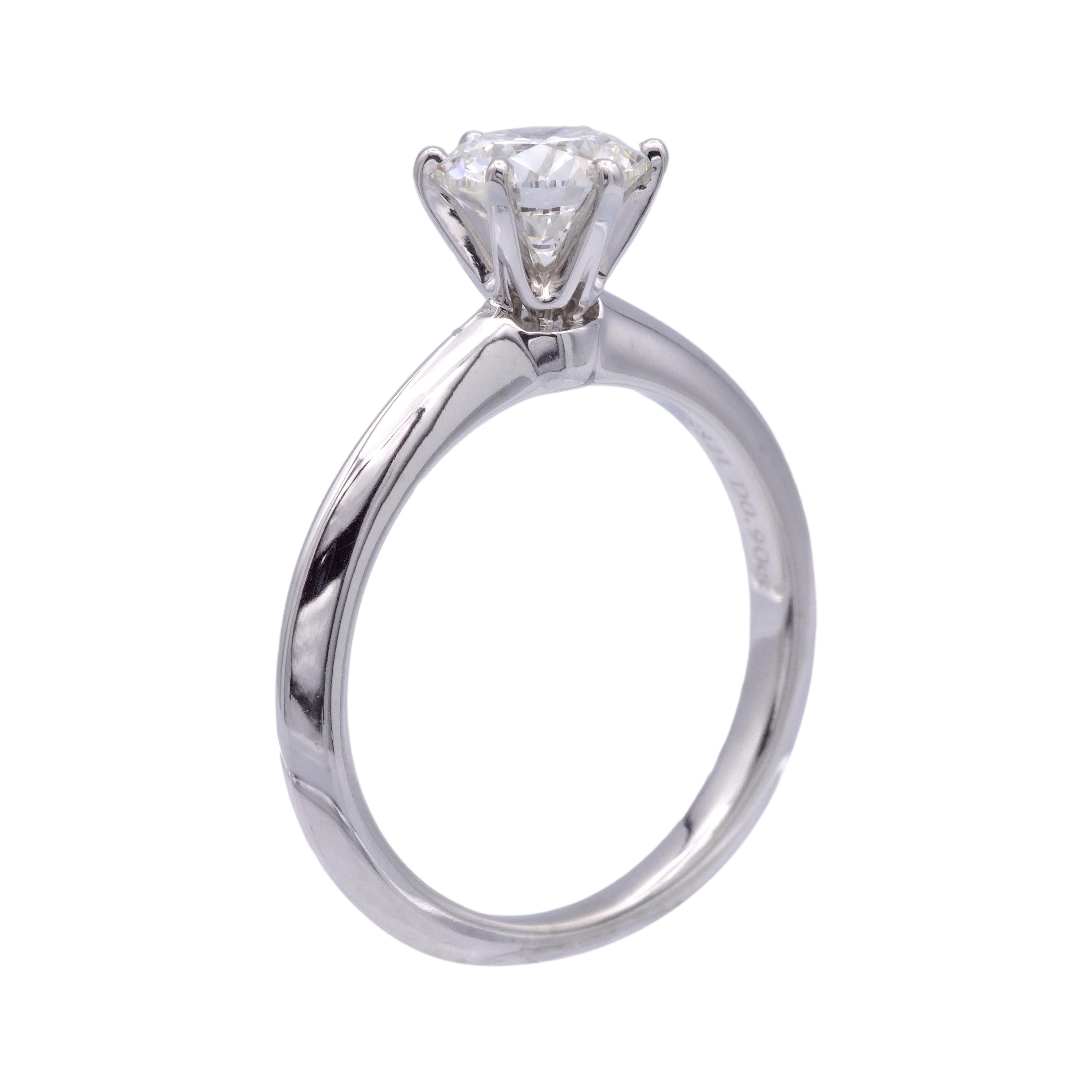 Tiffany & Co. solitaire engagement ring finely crafted in a 6 prong platinum mounting featuring a triple X round brilliant cut center weighing 0.90 carats, G color VVS2 clarity diamond certified by the Gemological Institute of America with excellent