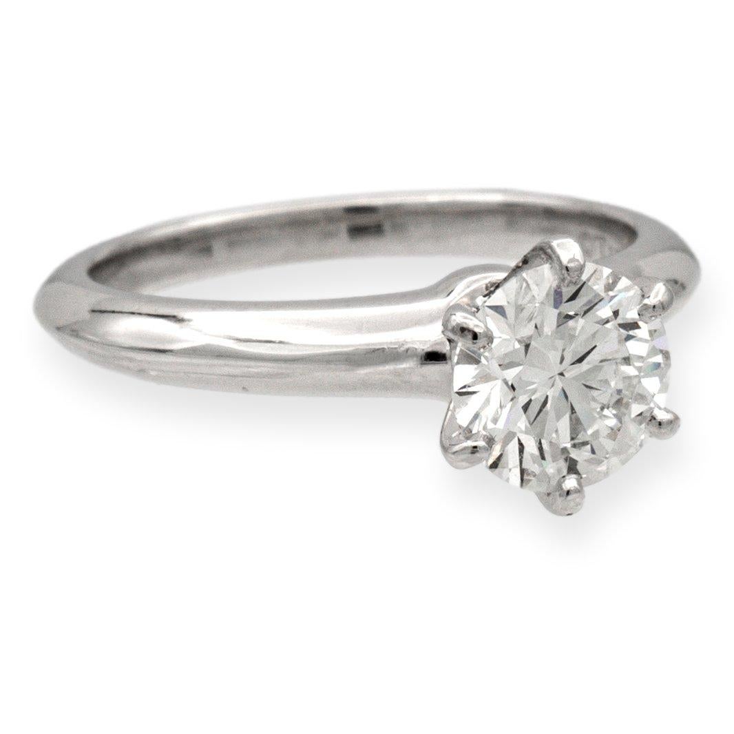 Tiffany & Co. Solitaire diamond engagement ring finely crafted in a six prong platinum mounting featuring a 1.17 carat round brilliant diamond center graded I color and VVS1 clarity. The diamond is inscribed with Tiffanys serial numbers and has