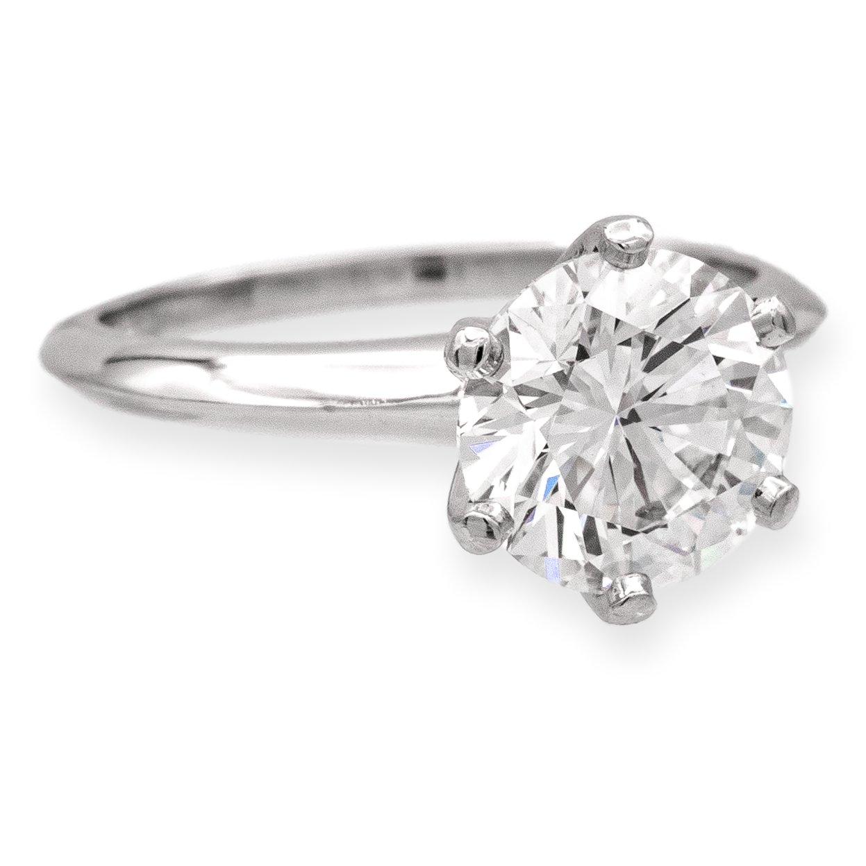 El anillo de compromiso solitario de platino Tiffany & Co. es una pieza elegante y atemporal que simboliza el amor y el compromiso. El anillo está finamente elaborado con una montura de seis garras de platino, que muestra el diamante redondo de