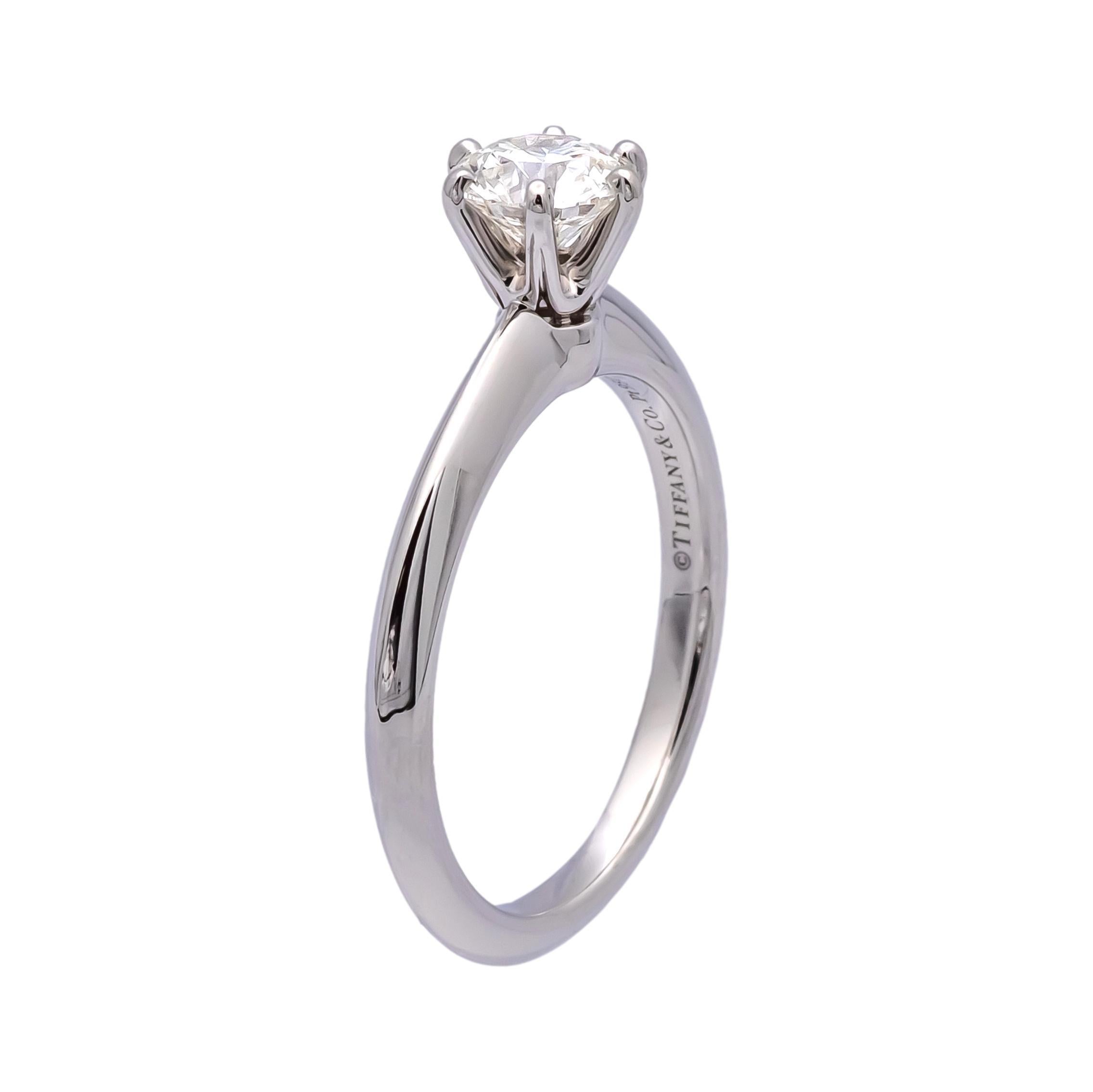Pre-owned Tiffany & Co. solitaire engagement ring finely crafted in a 6 prong platinum mounting featuring a round brilliant cut center weighing 0.70 carats, I color VS1 clarity diamond considered triple 