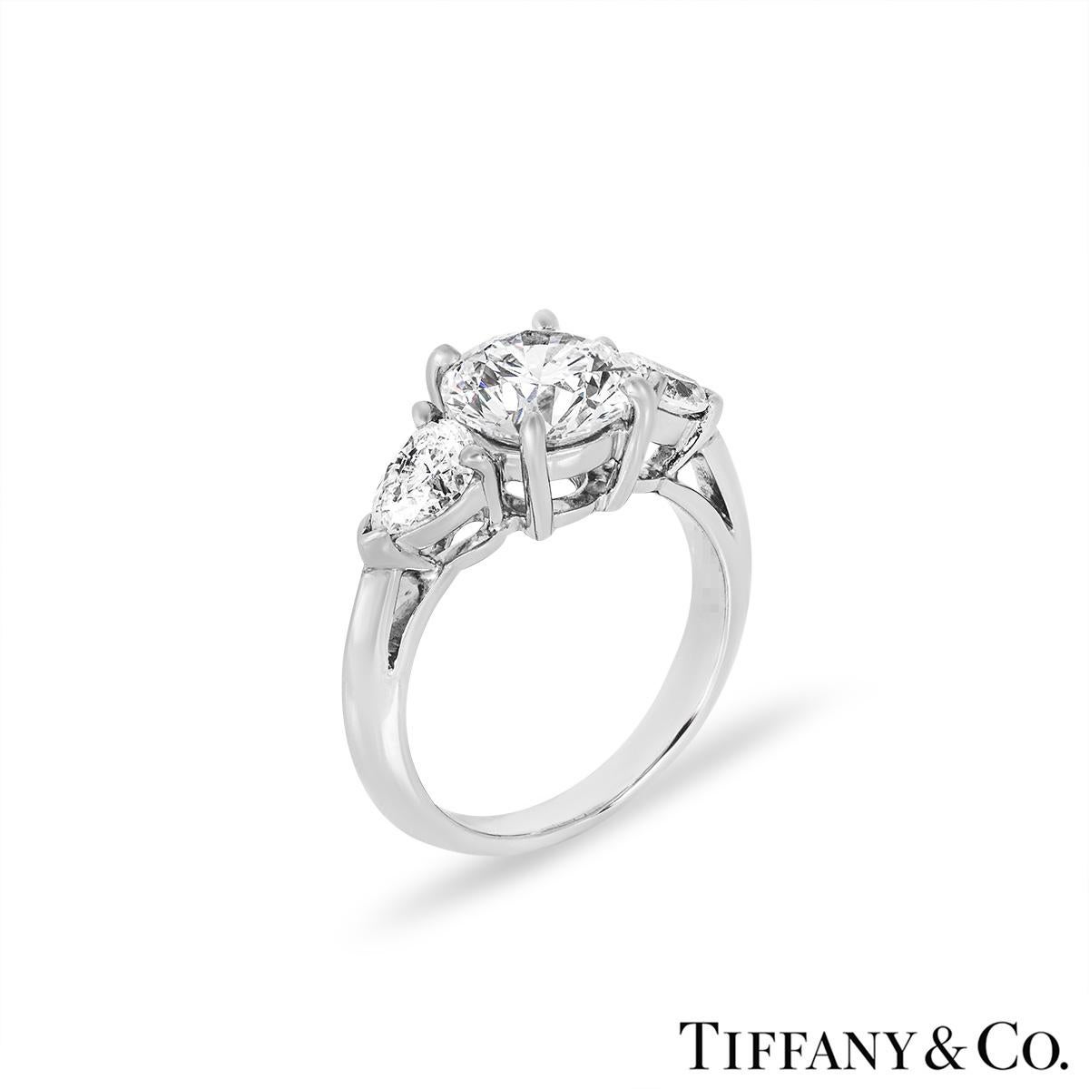 A stunning diamond engagement ring from Tiffany & Co. The three stone ring is set to the centre with a round brilliant cut diamond weighing 1.65ct, G colour and VVS2 clarity. The diamond scores an excellent rating in all three aspects for cut,