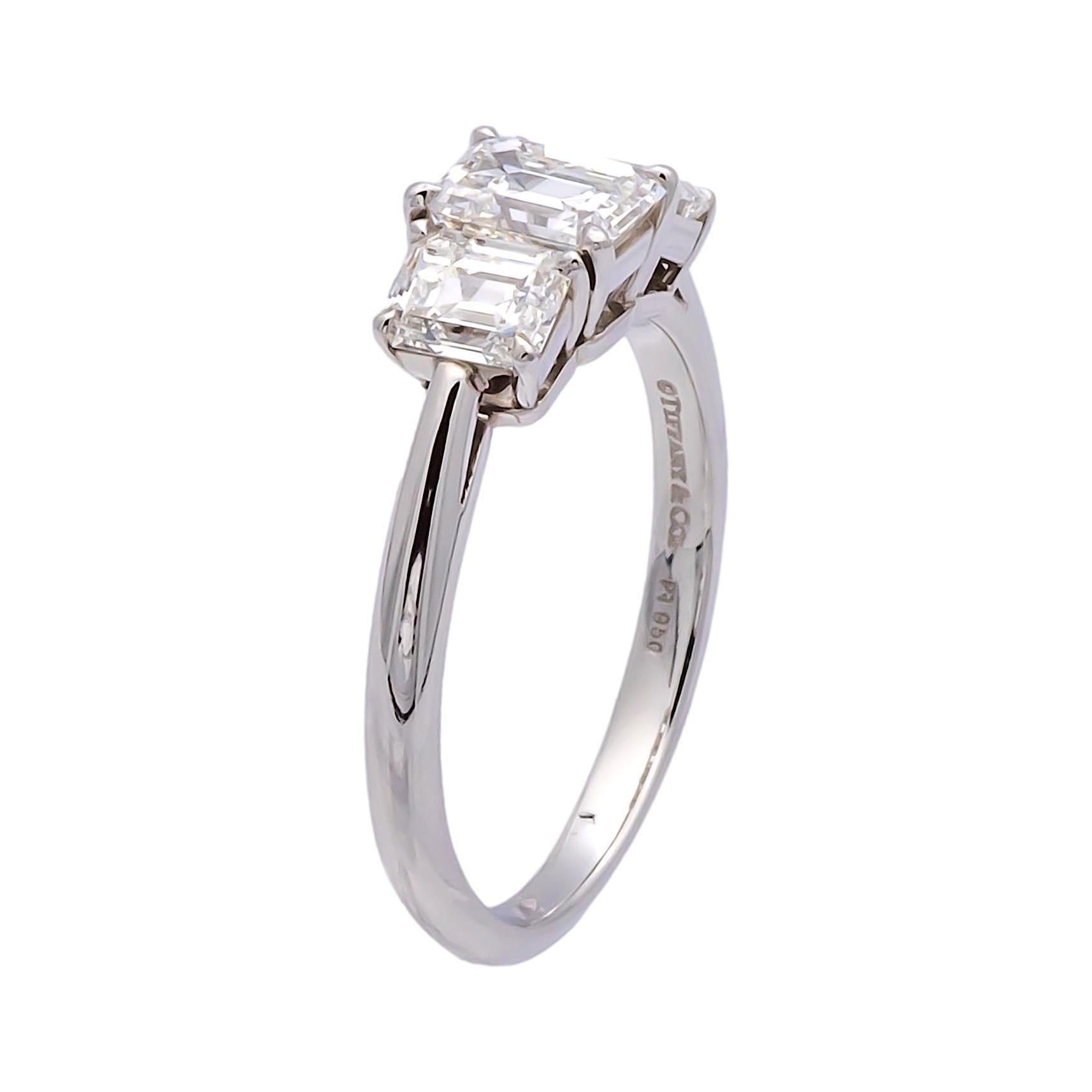 Vintage Pre-Owned Tiffany & Co. engagement ring finely crafted in platinum featuring three emerald cut diamonds with the main center stone weighing 0.75 carats , flanked by two side stones that weigh 0.42 carats each for a total of .84 carats. All