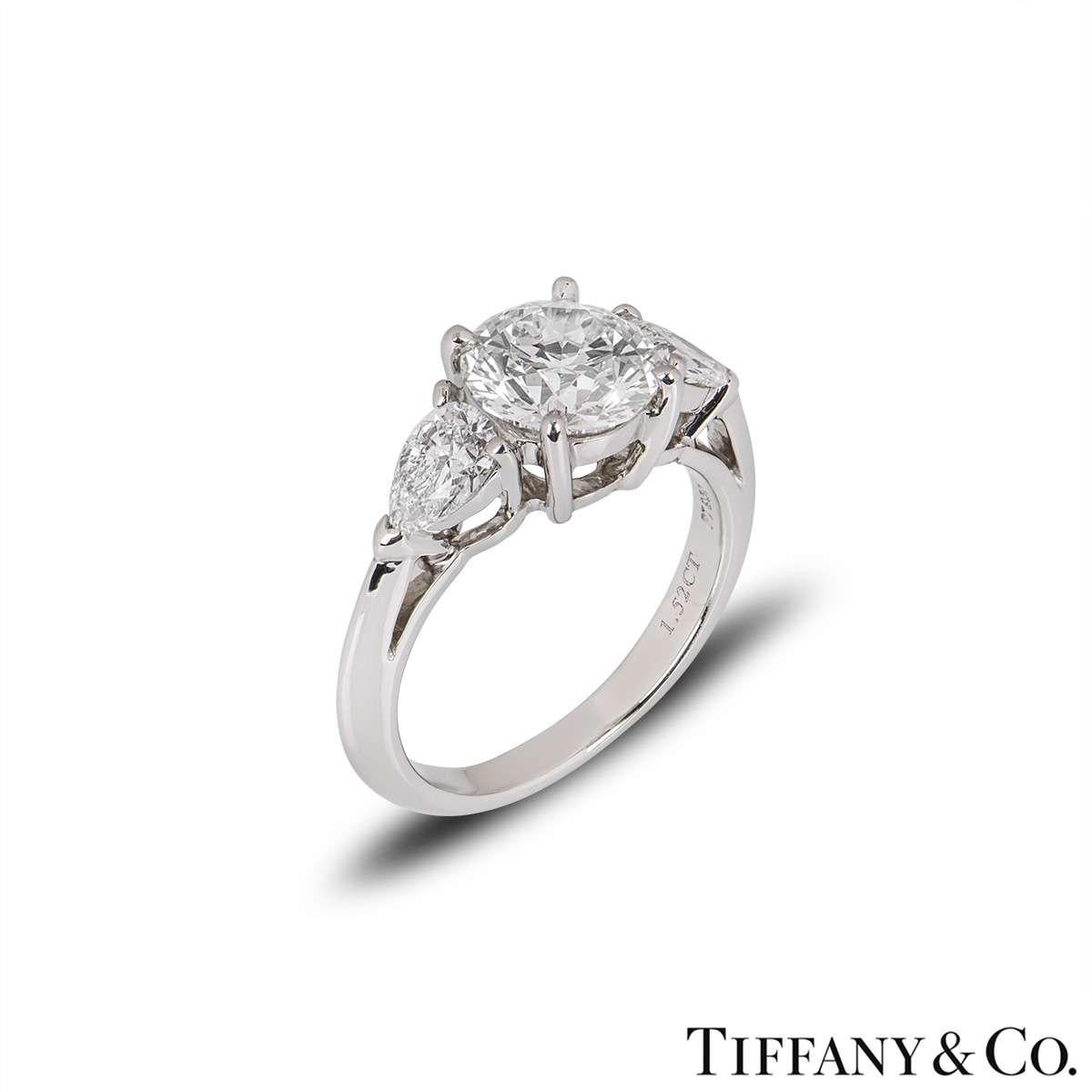 A stunning three stone platinum diamond engagement ring by Tiffany & Co. The ring is set to the centre with a 1.52ct round brilliant cut diamond, G colour and VS1 clarity. Complementing the diamond are two pear cut diamonds on either side totalling
