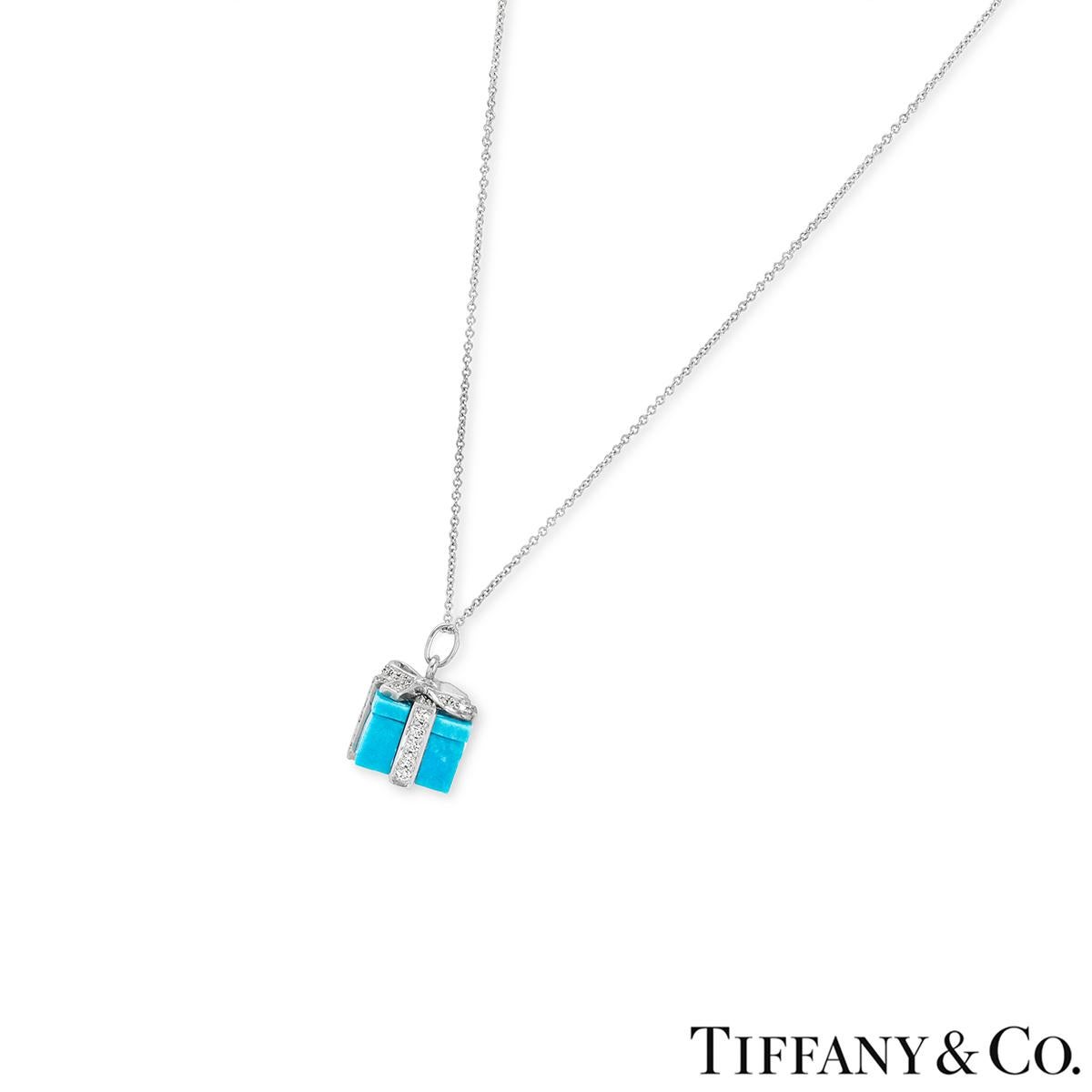 A charming platinum turquoise and diamond pendant by Tiffany & Co. The pendant comprises of a gift motif carved from vibrant turquoise and adorned with a diamond set ribbon and bow. The ribbon and bow feature 58 round brilliant cut diamonds with an