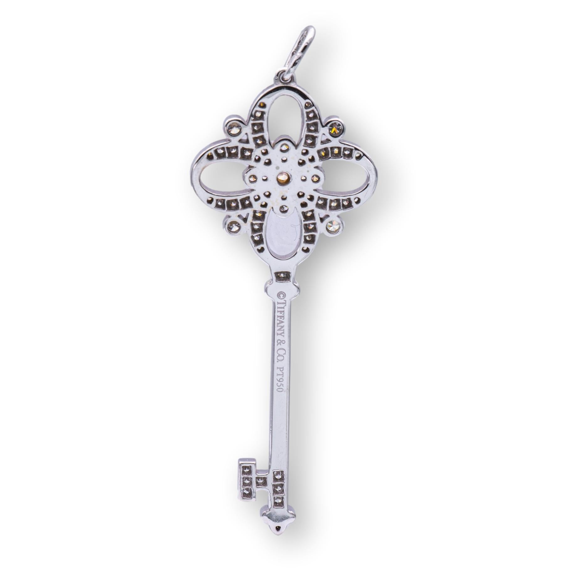Tiffany & Co. Key pendant from the floret collection finely crafted in platinum featuring a center round brilliant Fancy Intense pink diamond weighing 0.05. cts set inside a bezel complemented by white round brilliant cut diamonds weighing 0.44