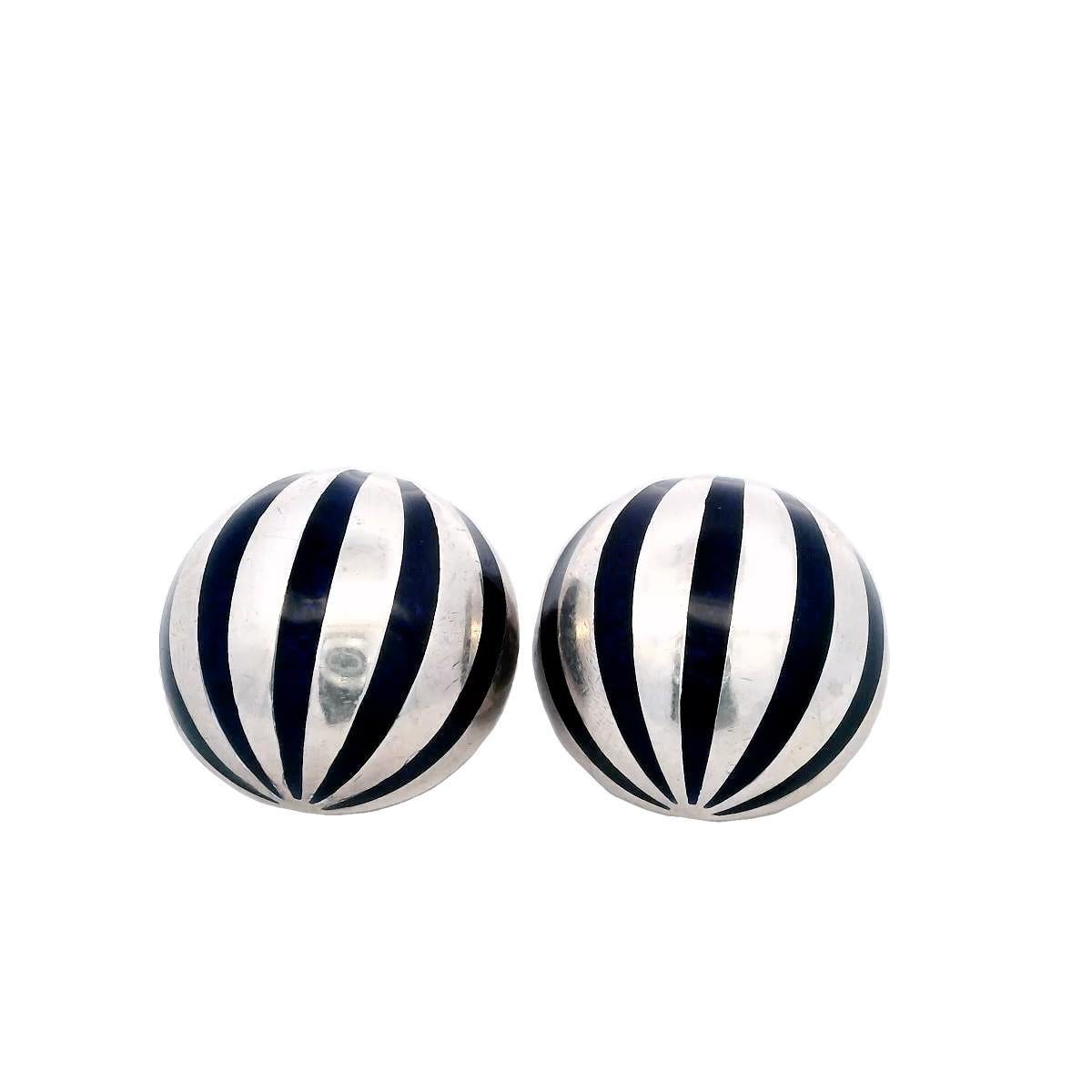 Tiffany & Co. Orecchini a clip in smalto e argento sterling

Questi orecchini presentano un design audace con strisce alternate di smalto nero e argento sterling, creando un forte contrasto visivo. La forma sferica conferisce un tocco di modernità,
