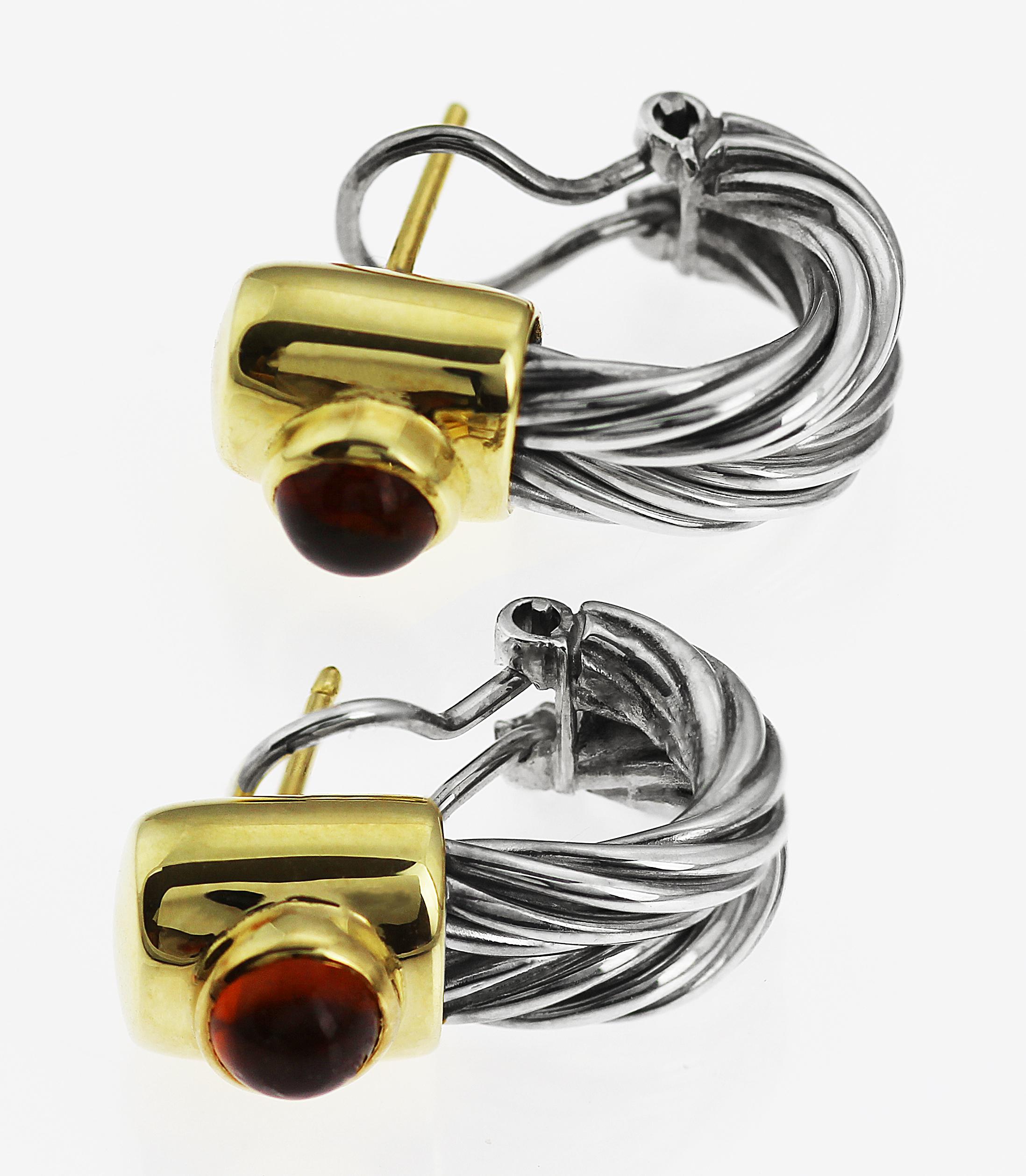A beautiful design by Tiffany in silver and 18 ct yellow gold pair of earrings. A twisted wire cable-style with cabochon rare red amber on top, in 18 ct yellow gold with easy to wear pin and wire fittings. 
Retired earrings with British hallmarked