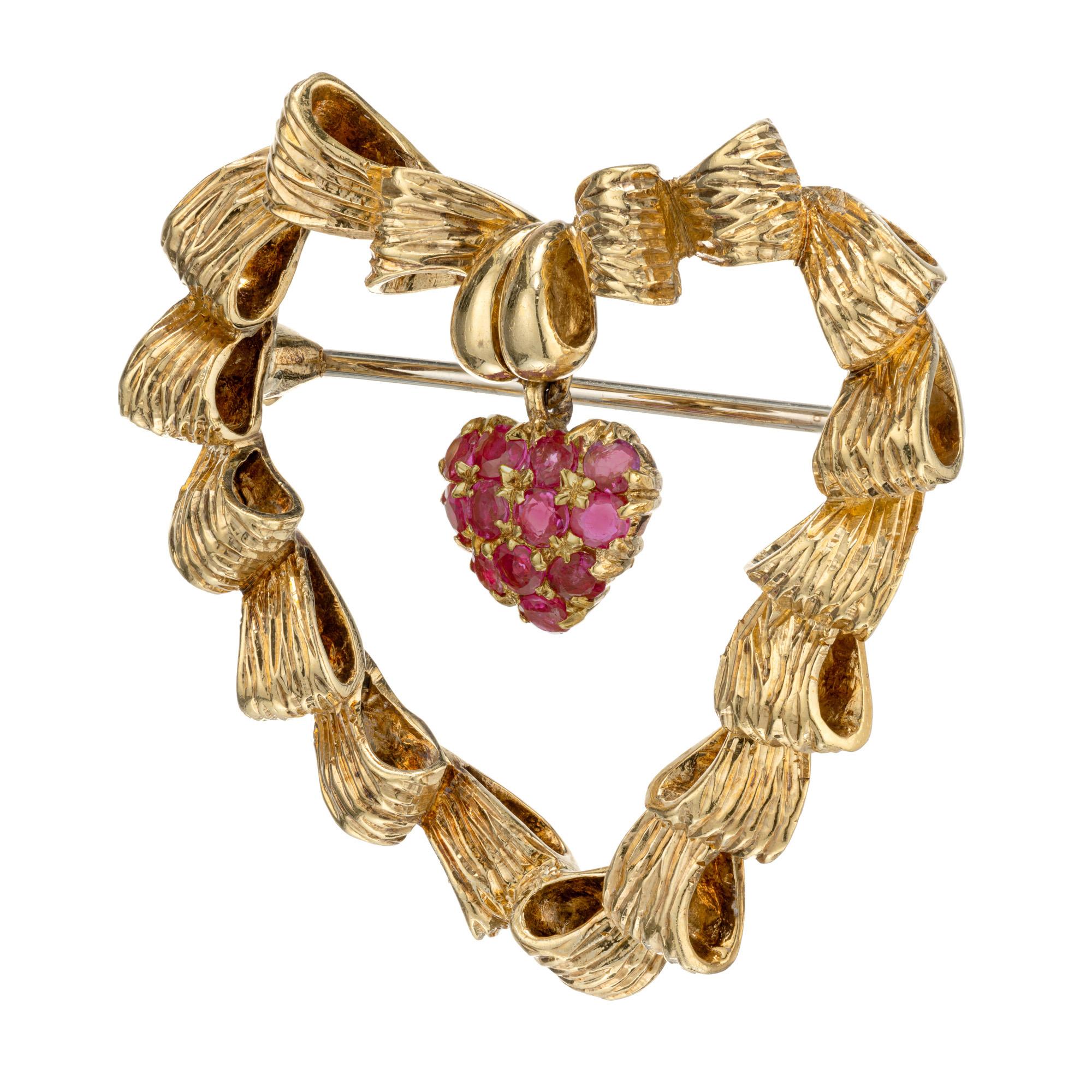 Tiffany & Co circa 1950 to 1960 solid 18k yellow gold Italian made heart brooch, with 12 round rubies in a heart shape dangle. 

12 round fine natural Rubies, approx. total weight .80cts, VS, gem pinkish red
18k Yellow Gold
Stamped: Tiffany & Co 18k