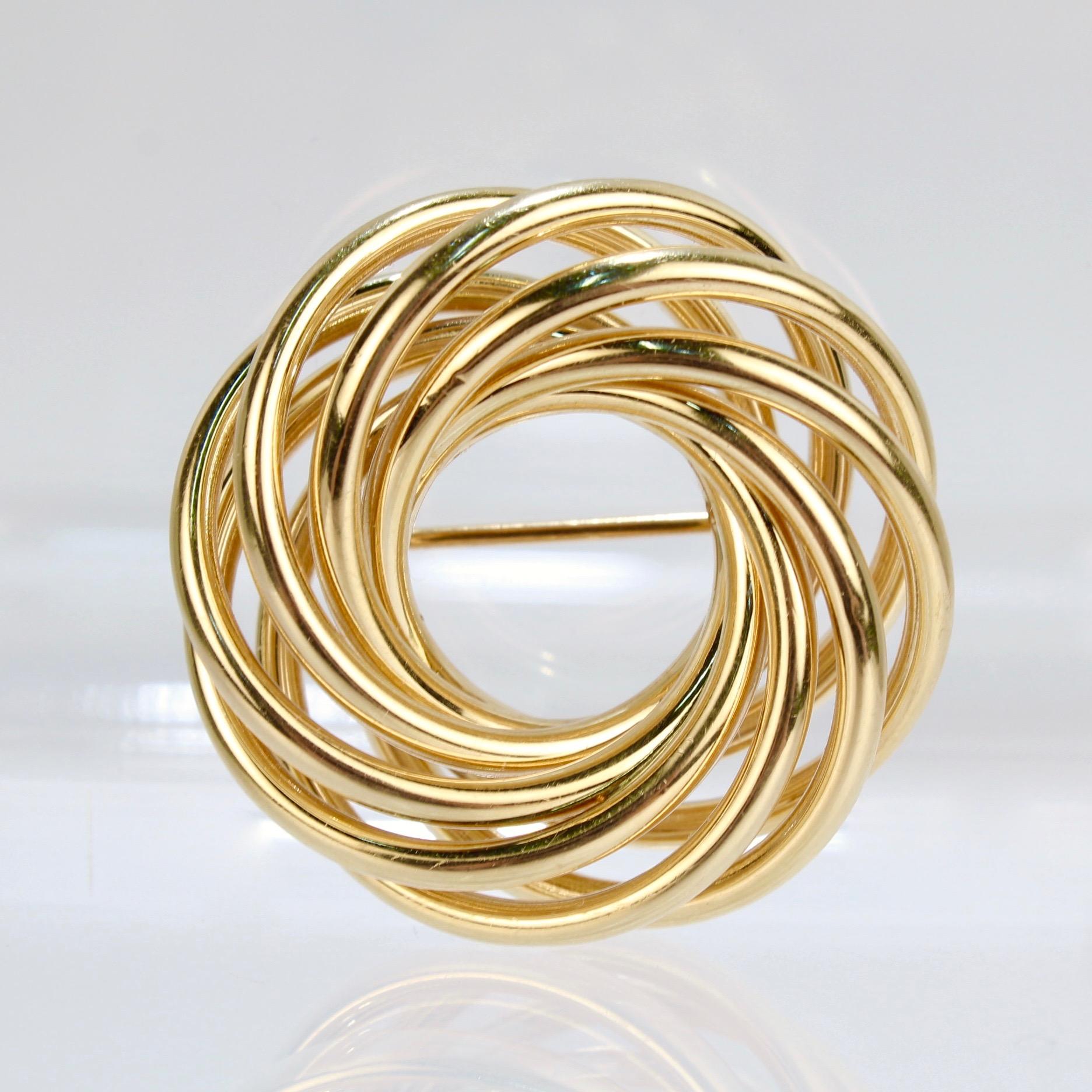 A very fine retro Tiffany & Co. 'Love Knot' brooch.

Crafted in 14k gold tubular rings in intertwined circles.

Marked 14k to the clasp for gold fineness and Tiffany & Co. on the pin stem.

A classic form with great retro style!

Diameter: ca. 37