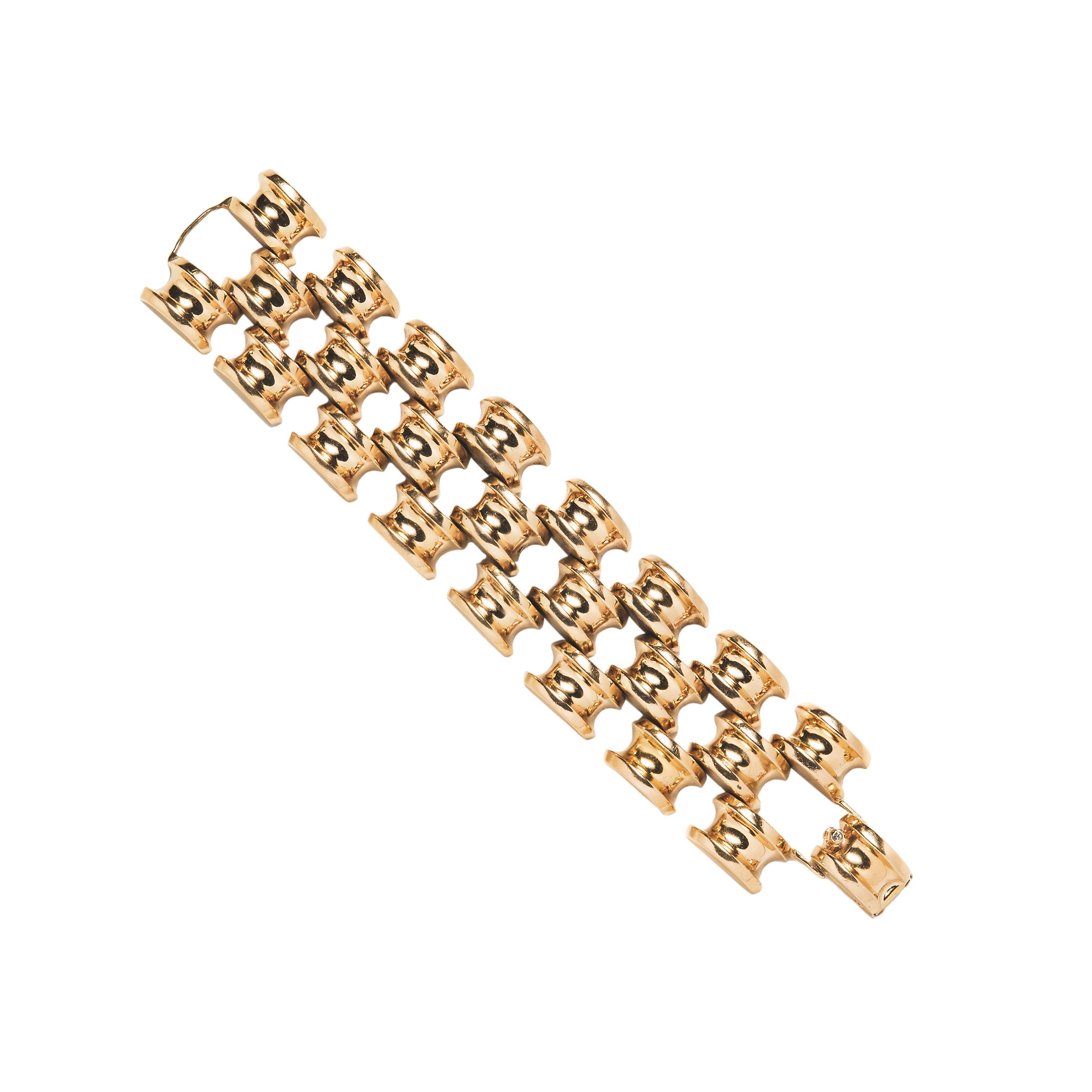 Crafted of 14kt yellow gold, this retro bracelet consists of three rows of articulated domed links in a stacked design. The flexible form wraps comfortably around the wrist and fastens with a fold over clasp highlighted by a single rose-cut