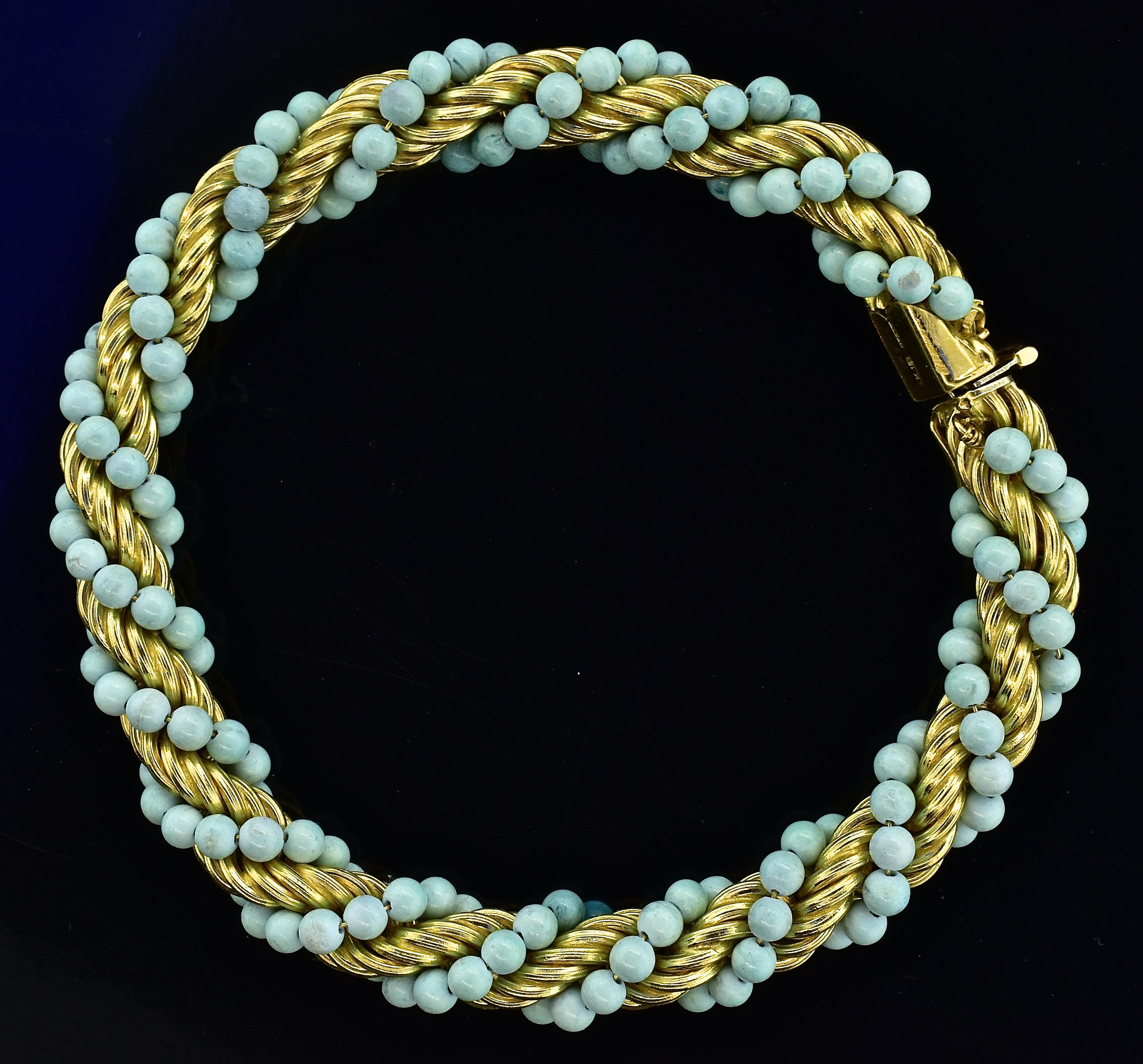 Tiffany and Co. vintage 18K gold bracelet with pastel blue-green turquoise wrapped around the rope style links.  The turquoise beads measures 1.5 to 2.0 mm., and the bracelet weighs 18.3 grams.  This type of bracelet was a popular motif by Tiffany