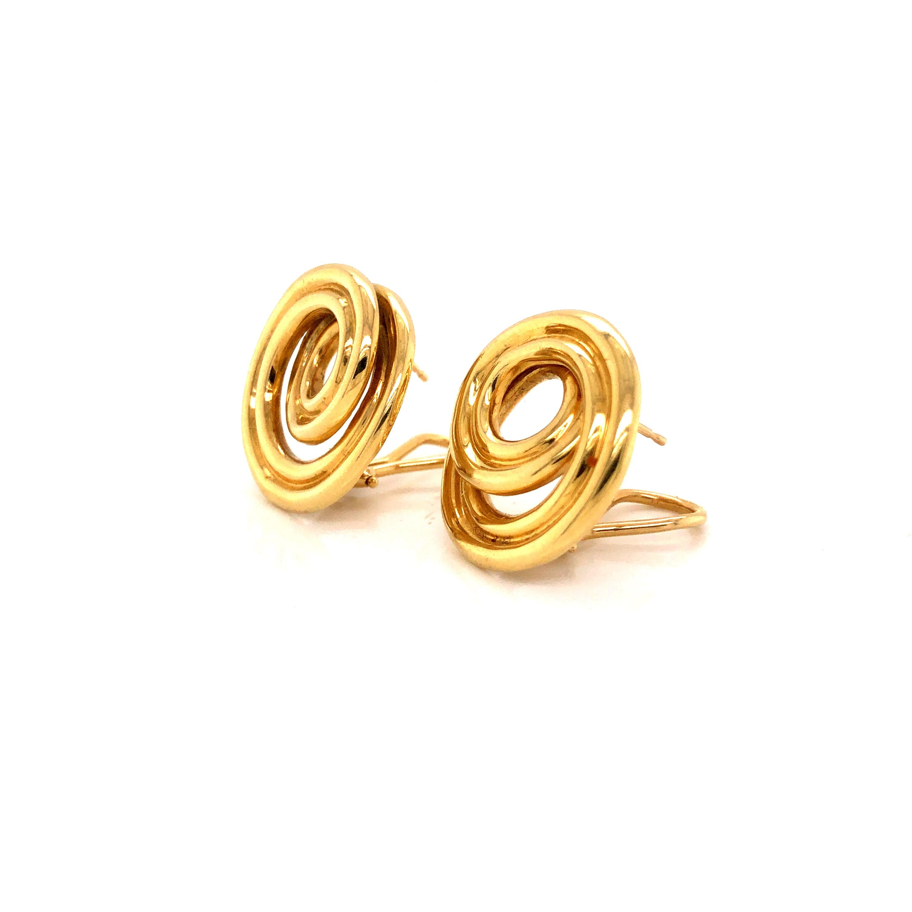 Beautiful earrings from famed jewelry house Tiffany & Co. These retro earrings are crafted in 18k yellow gold.  The pair displays a brilliant swirling pattern in a circular design.  The pair has a 3-D feel as the swirls come off the design. The pair