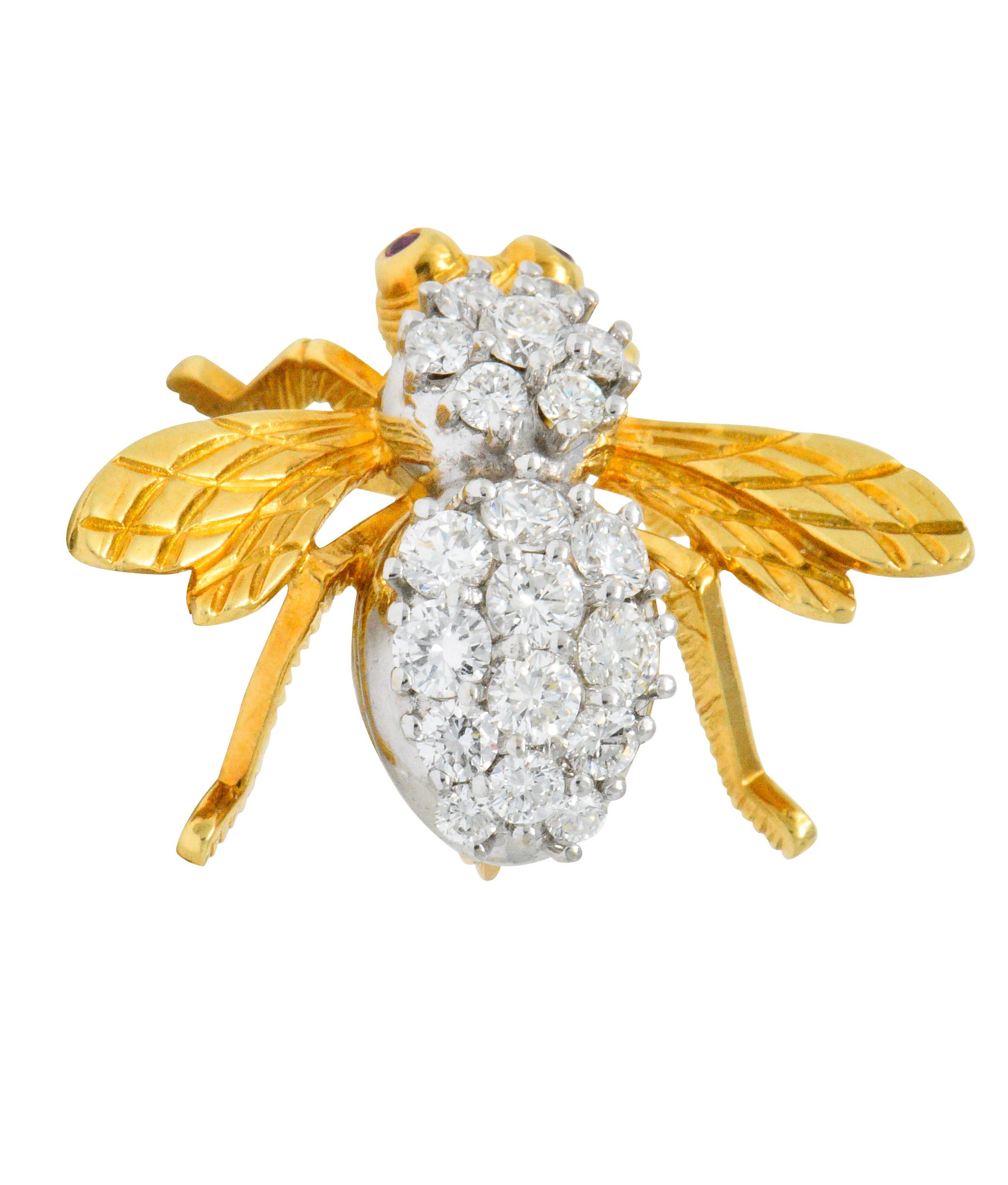 Designed as a bee with a round brilliant cut diamond set body weighing approximately 1.90 carats total, G/H color and VS clarity

With bezel set round cut ruby eyes weighing approximately 0.05 carats

Textured and engraved gold head, wings and