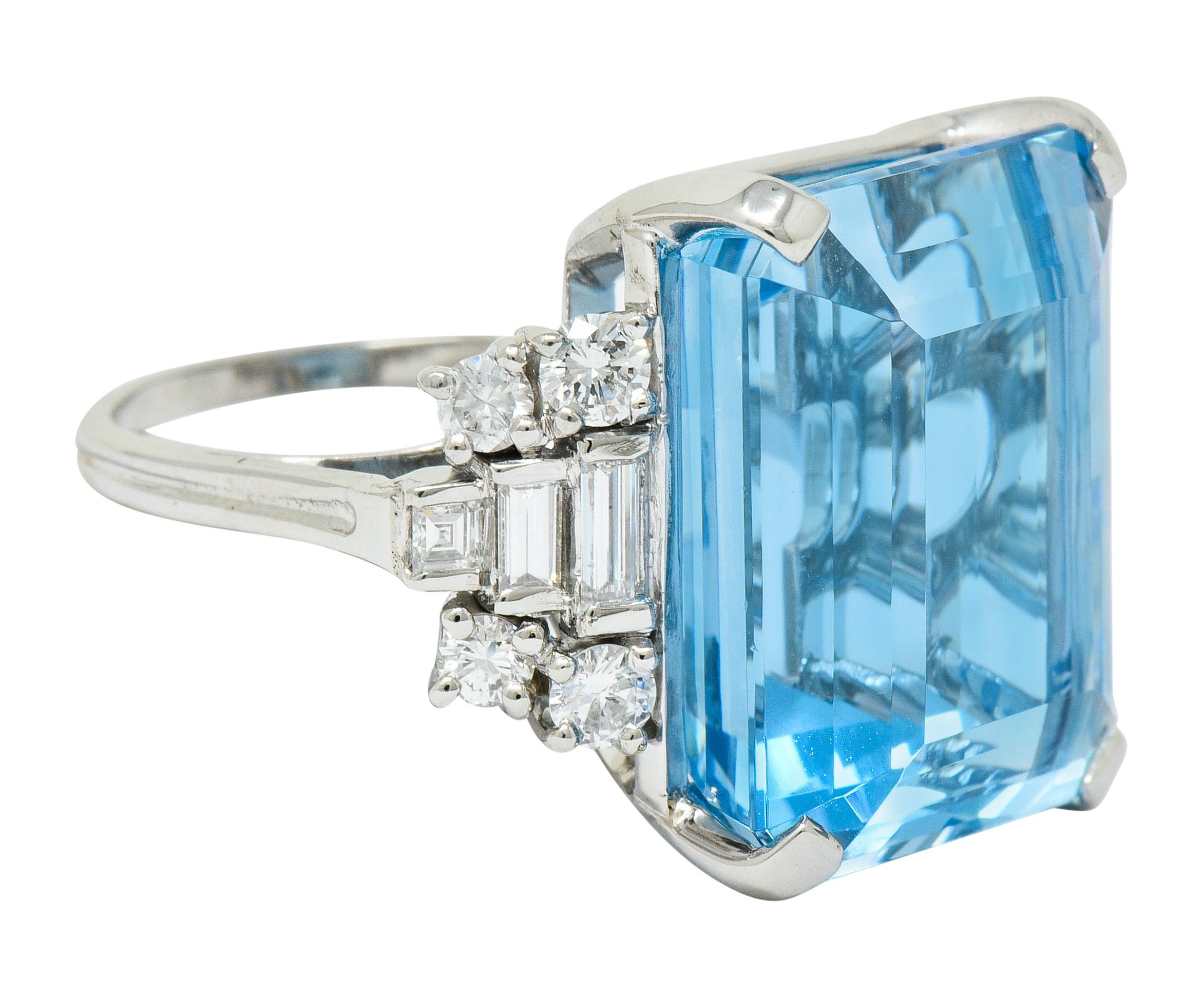 Centering an emerald cut aquamarine weighing approximately 28.10 carats, transparent and a saturated sky blue color

Flanked by stepped shoulders accented by round, baguette, and step cut diamonds weighing in total approximately 1.20 carats; F/G