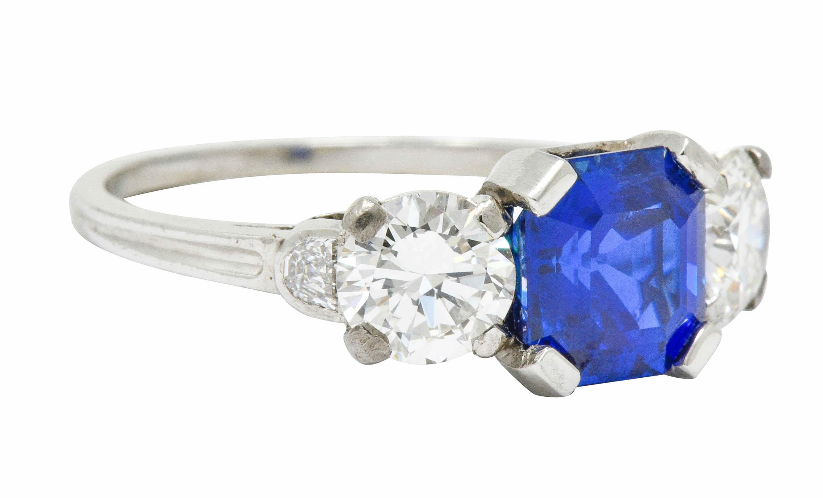 Centering a square step cut Ceylon sapphire weighing 2.25 carats; bright royal blue in color with no evidence of heat

Flanked by two transitional cut diamonds weighing 1.12 carats total, F/G color with VS clarity

Each shoulder accented by half
