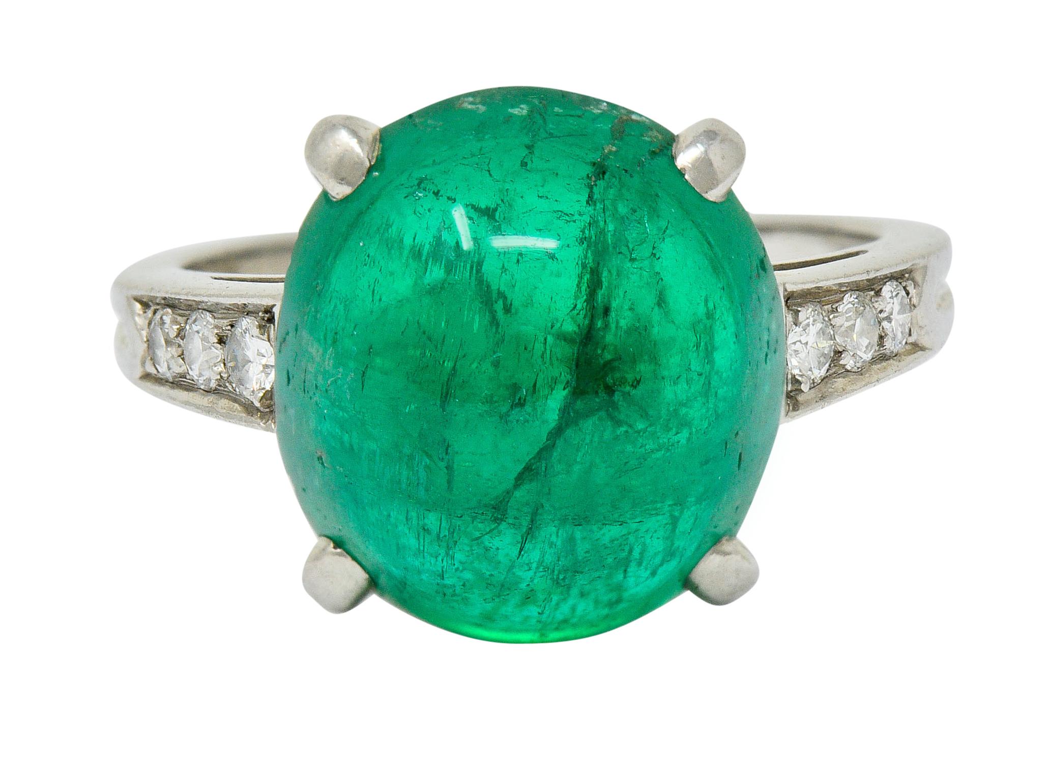 Basket cathedral style ring centering an oval emerald cabochon weighing approximately 7.00 carats

Vividly green in color and translucent with natural inclusions indicating Colombian origin; faint traditional clarity enhancement

Flanked by round