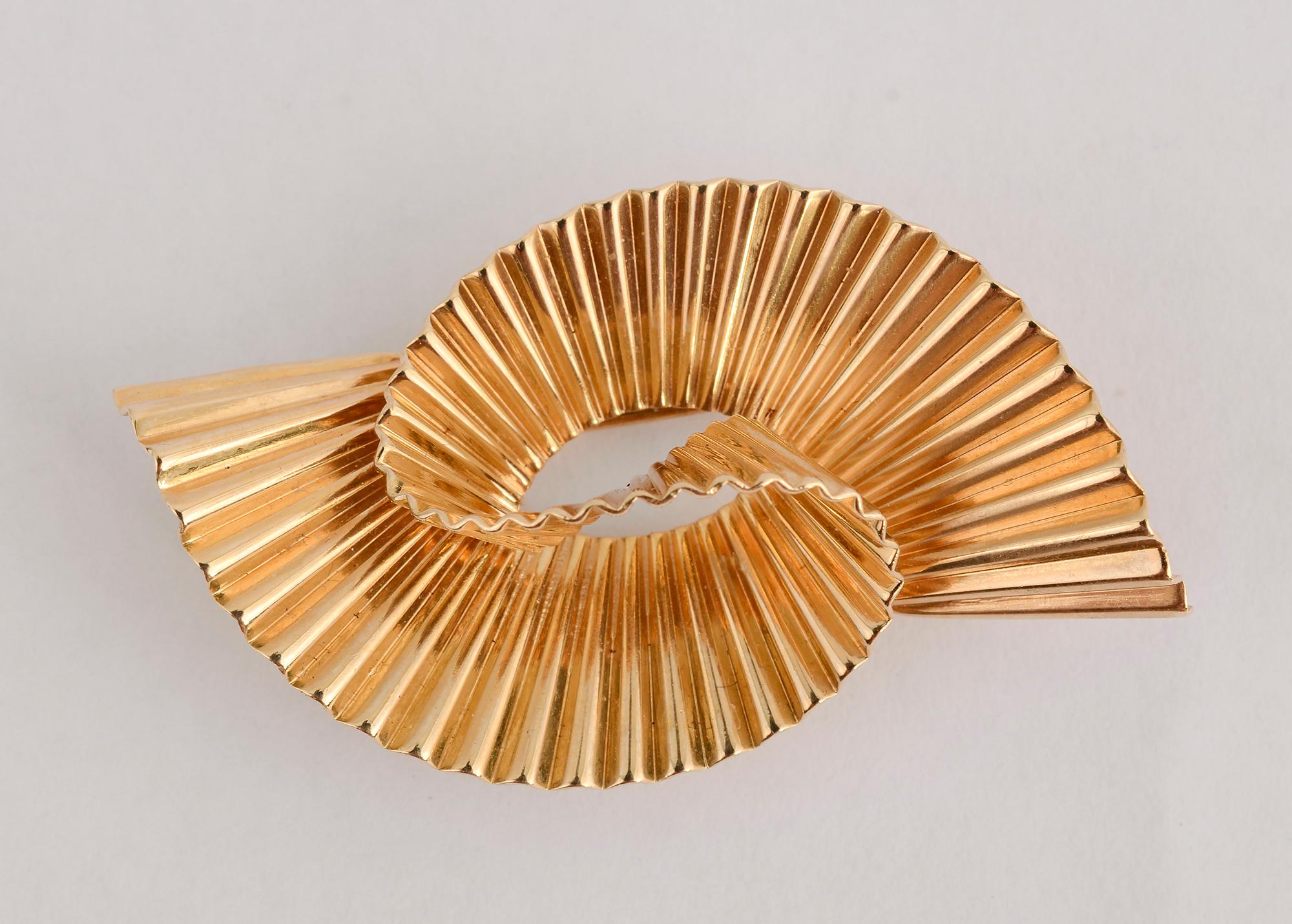 Tiffany double swirl brooch that is totally Retro in every way. The three dimensional swirl design made of 14 karat ribbed gold is emblematic of the era. The fluted gold adds great reflectivity to the piece.
It has double pin stems. The brooch can
