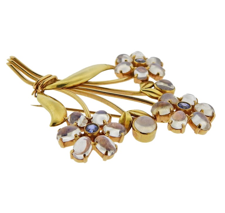 Retro 14k gold flower brooch by Tiffany & Co, set with moonstones and blue sapphires. Measures 71mm x 64mm. Marked Tiffany & C and 14k. Weighs 20.6 grams.

SKU#PB-02118