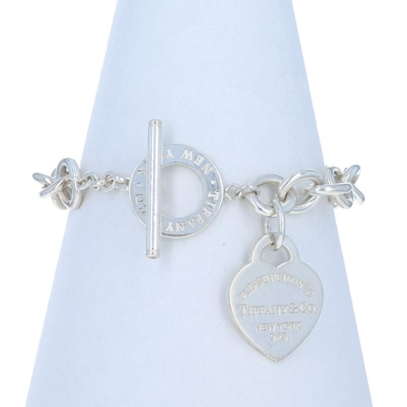 Prezzo al dettaglio: $725

Marchio: Tiffany & Co.
Design:  Torna a Tag Tiffany Heart Toggle 

Contenuto del metallo: Argento Sterling

Stile della catena: Cavo
Stile del braccialetto: Catena
Tipo di chiusura: Chiusura a ginocchiera
Tema: Cuore,