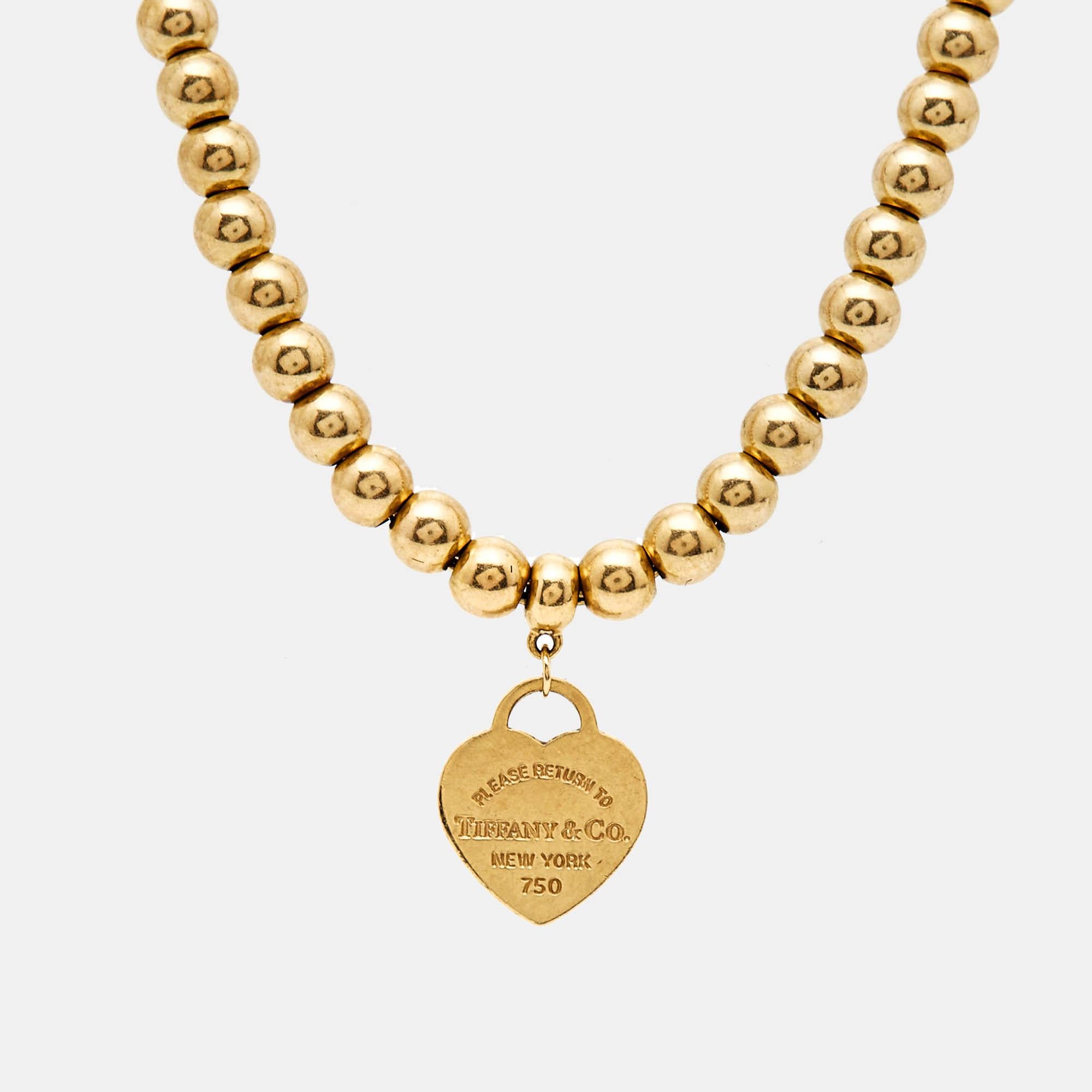 Sculpted with exquisite attention to detail, the Return To Tiffany bracelet exudes timeless charm. Made of radiant 18k yellow gold, it features a delicate beaded chain design. The iconic heart tag adds a touch of romantic elegance, making it a