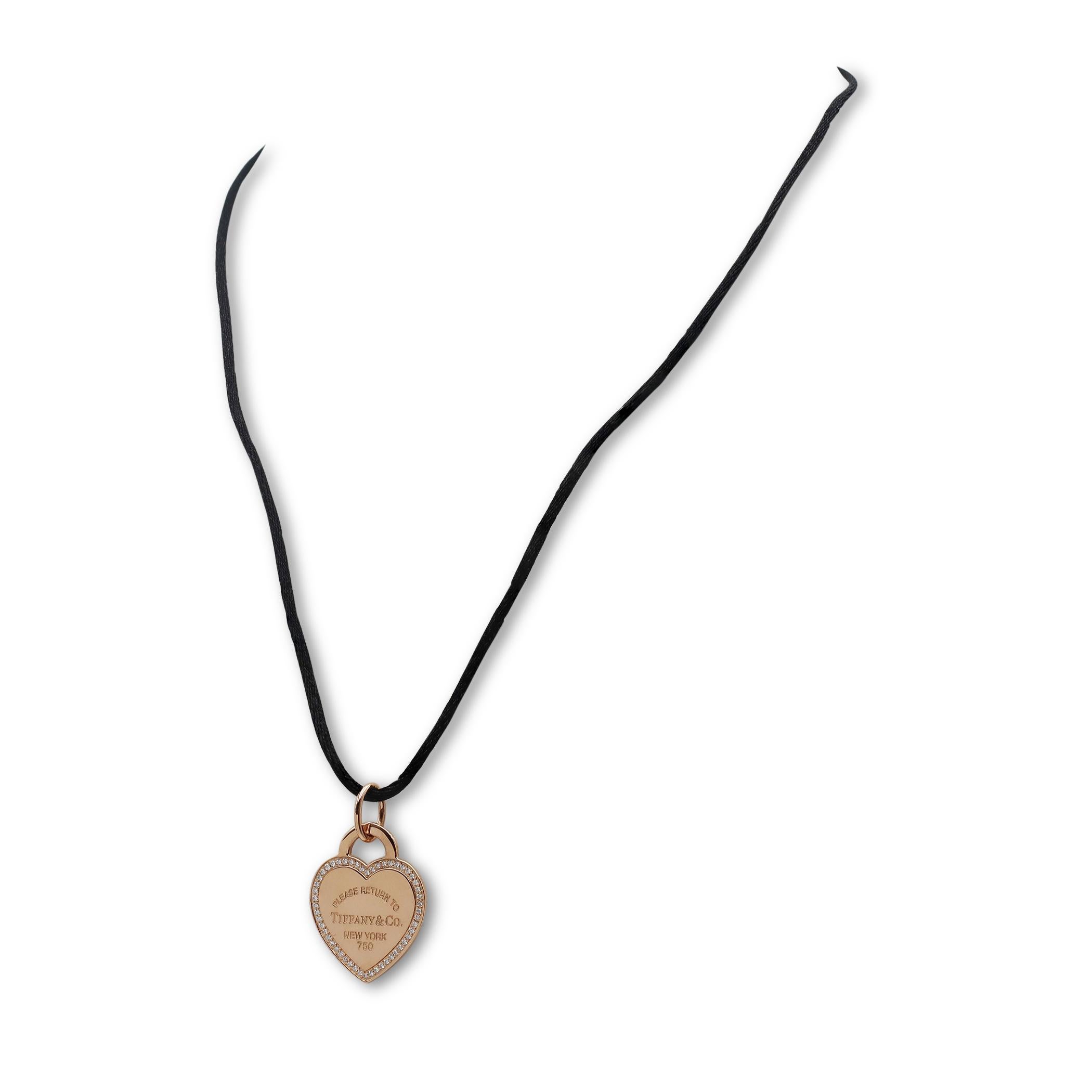 Authentic Tiffany & Co. 'Return to Tiffany' heart pendant crafted in 18 karat rose gold featuring the signature Tiffany & Co. engraving surrounded by an estimated 0.20 carats of round brilliant cut diamonds. The pendant measures 20.9mm in width x