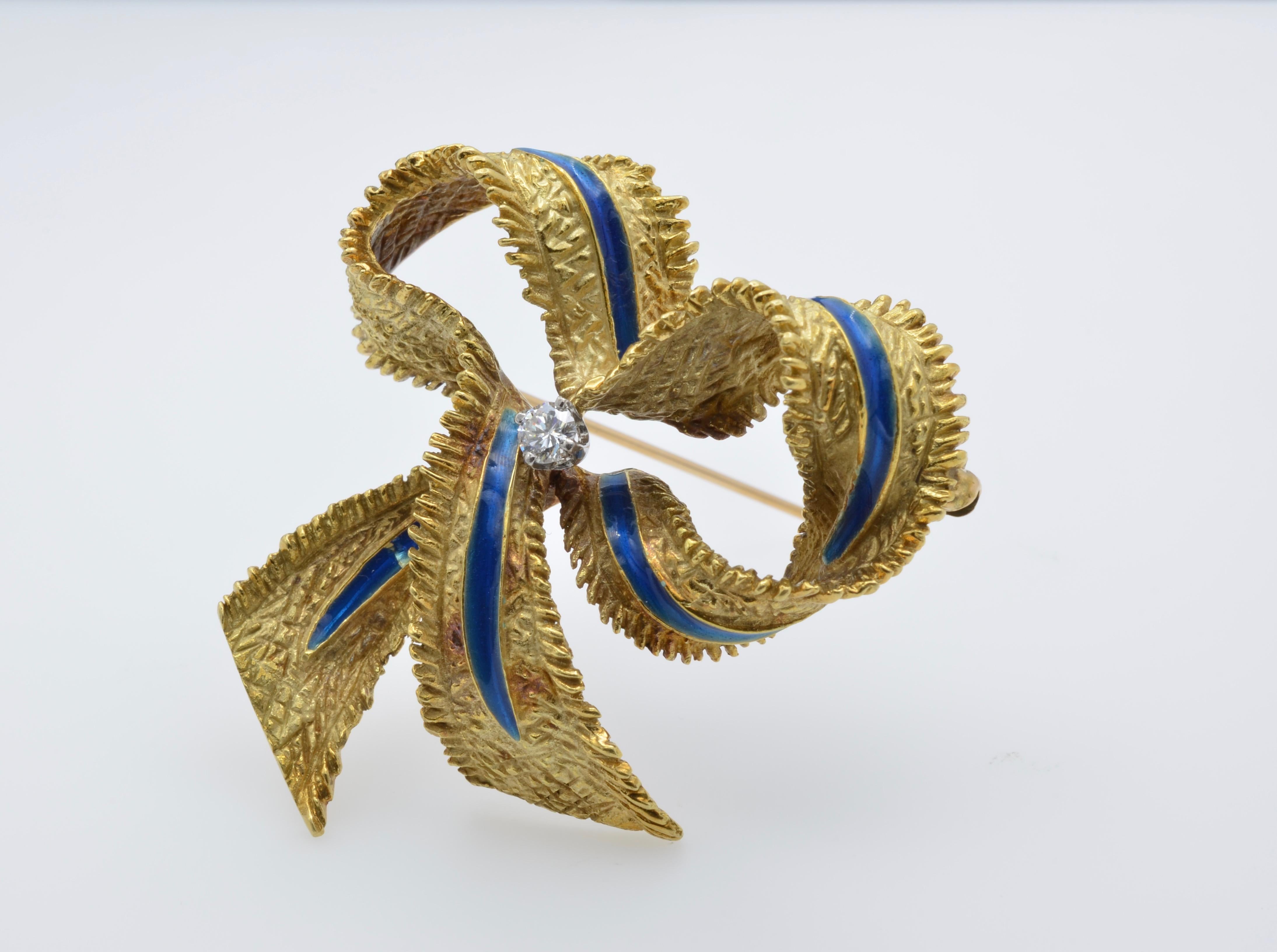 Iconic Ribbon from Tiffany with blue enamel, 18K yellow gold, and a central diamond. The diamond is 0.15cts and color GH VS2. It has elegant exquisite texture and beautiful contrast with the a blue line of enamel on every curve and a gorgeous center
