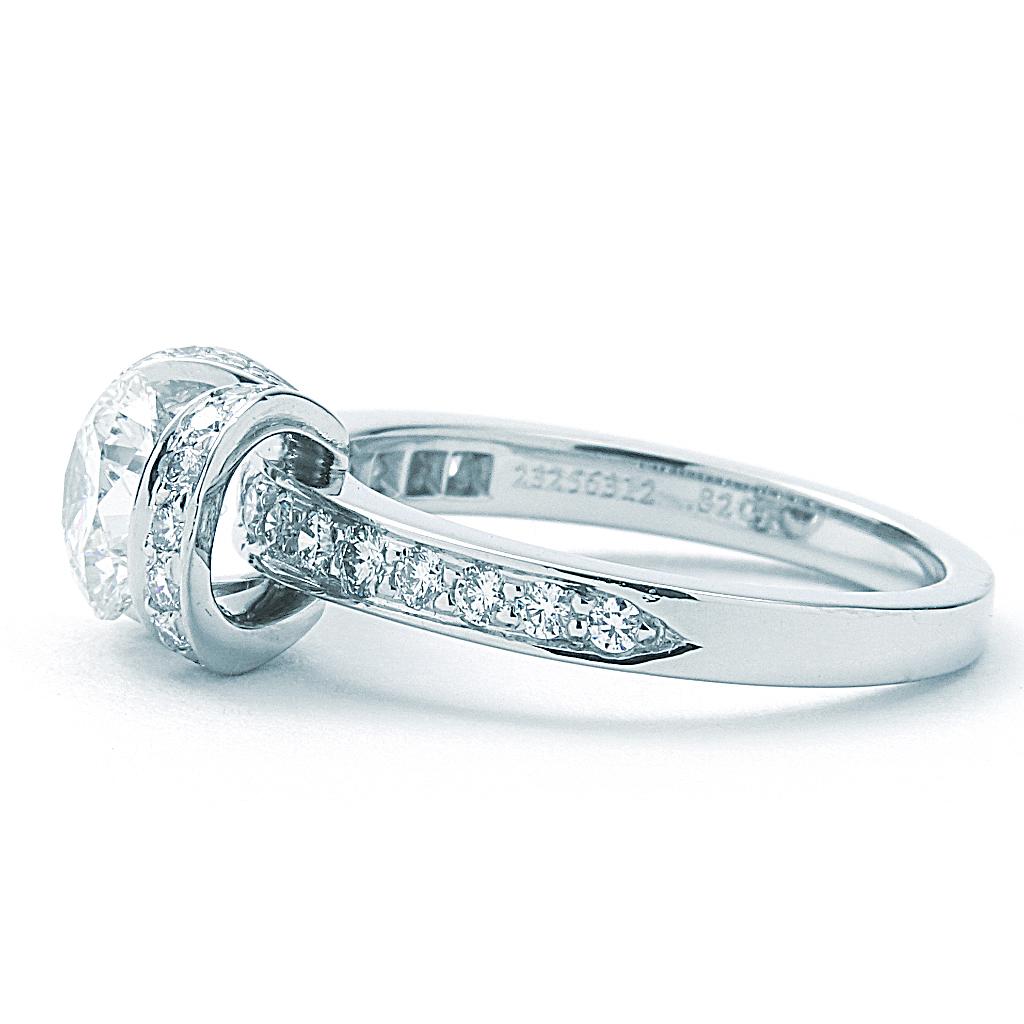 Previously-owned Tiffany & Co. Ribbon engagement ring. The ring is a size 4.25 (US), made of 950 platinum, and weighs 3.20 DWT (approx. 4.98 grams). It also has one I-color, VS1-clarity diamond weighing 0.82 CT, and 29 F/G-color, VS-clarity diamonds