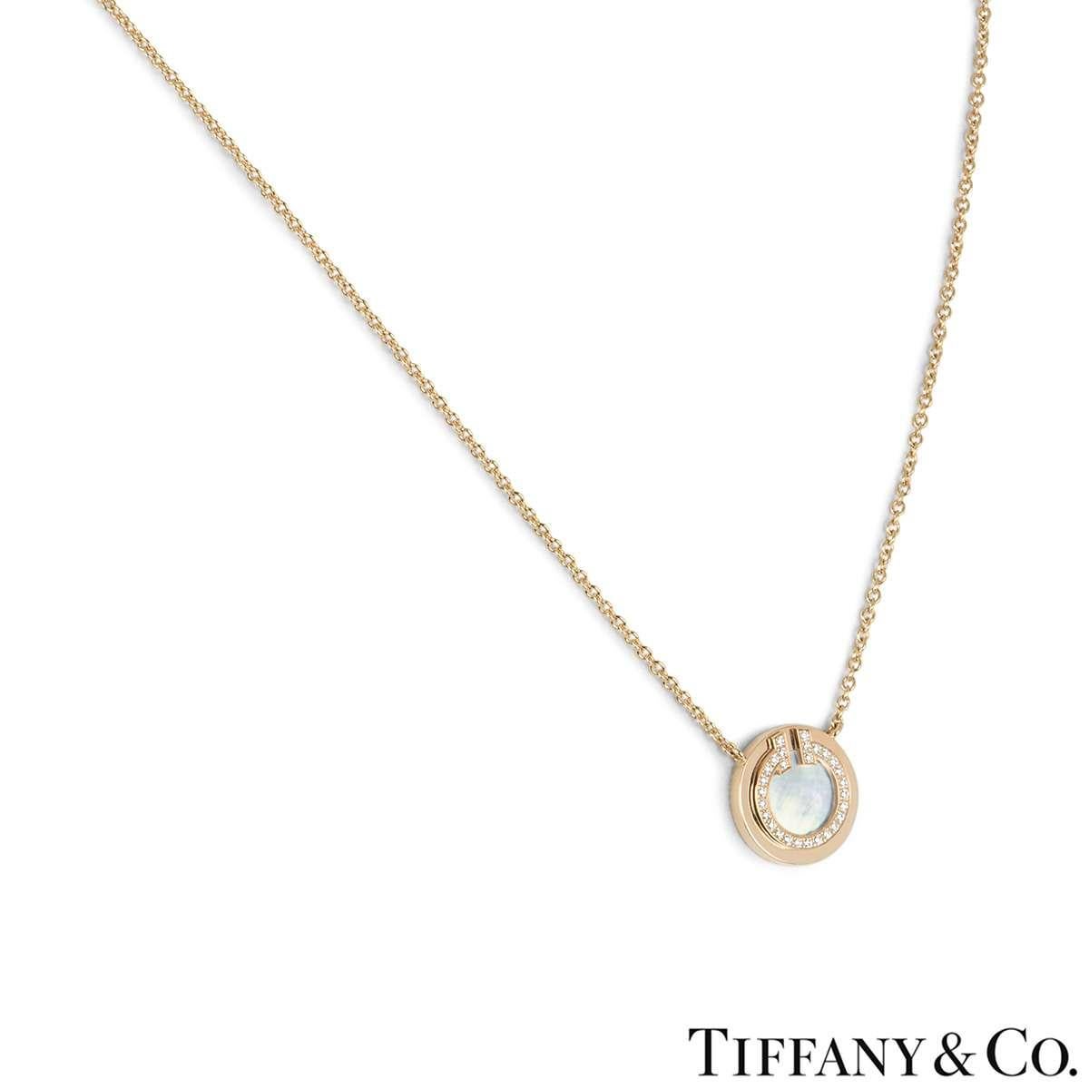 An 18k rose gold pendant from the Tiffany T collection by Tiffany & Co. The pendant comprises of a mother of pearl disk in the centre surrounded by a boarder of round brilliant cut diamonds. There are 28 diamonds with a total weight of 0.03ct. The