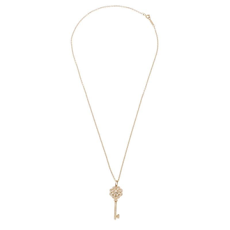 Tiffany & Co. presents this elegant pendant necklace that is sure to catch an eye. Designed in the shape of a key in 18K rose gold metal and flaunting brilliant round cut diamonds, this pendant has a long chain that features the brand name engraved