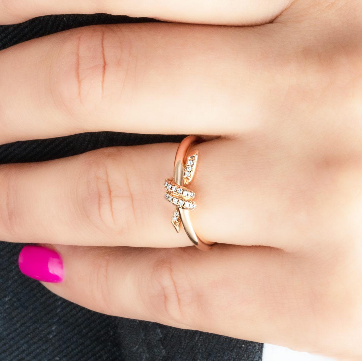 An 18k rose gold ring by Tiffany & Co. from the Knot collection. The ring features a knot motif at the centre of the band which is set with round brilliant cut diamonds, with a total weight of 0.05ct. The 2mm wide ring is a size J and, has a gross