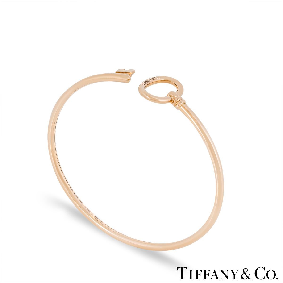 A chic 18k rose gold wire bracelet by Tiffany & Co. from the Tiffany Keys collection. The cuff style bracelet features a key design that wraps around the wrist. It measures 2.4mm wide, is a size medium that fits a wrist size up to 6.25 inches and