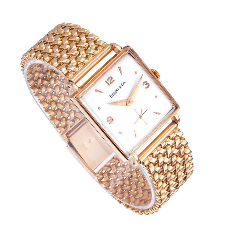 Orologio Tiffany & Co. Universal Geneve in oro rosa 18k del 1950 con cinturino in oro rosa e quadrante bianco sporco con indici e lancette in oro rosa. Realizzato all'insegna dell'eleganza e della raffinatezza, questo orologio senza tempo è un vero