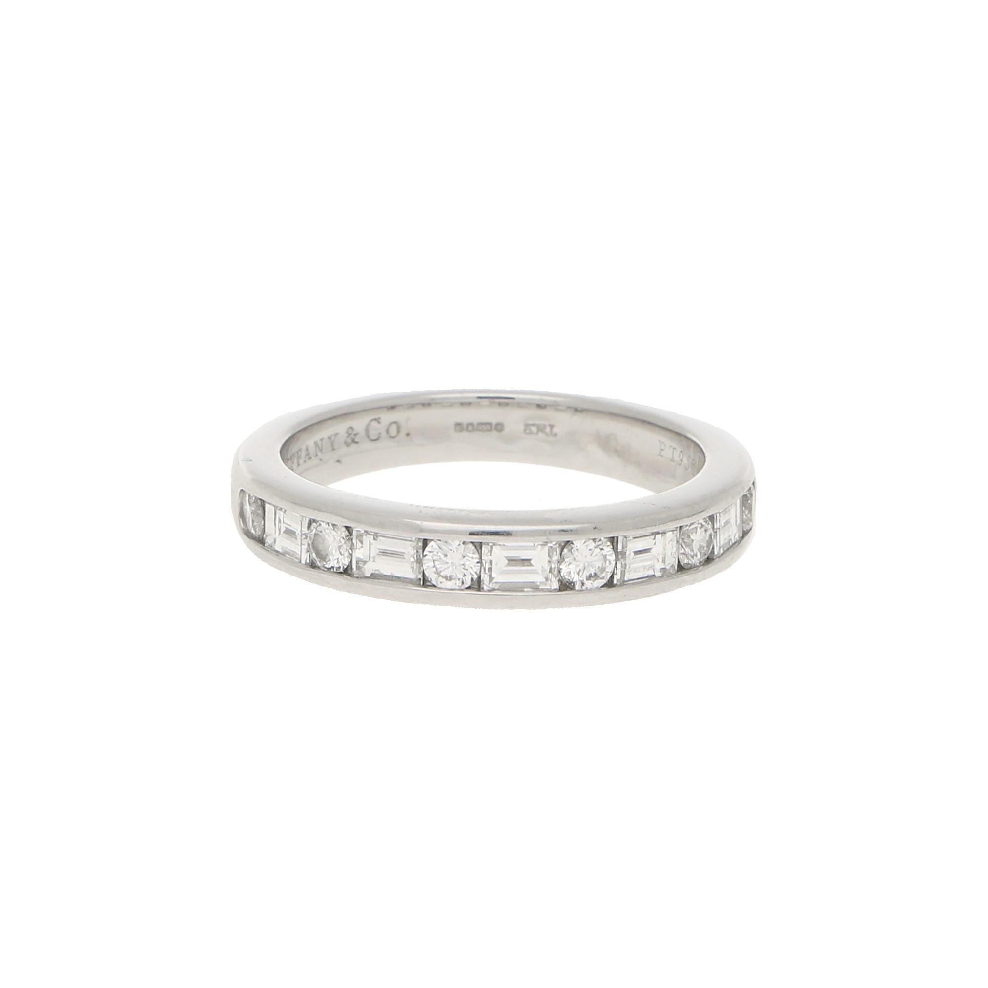 A lovely signed Tiffany & Co. diamond half eternity ring set in platinum.

The ring is set with exactly 11 sparkly diamonds, six of which being round brilliant cuts and the rest being baguette cut diamonds. All of which are rubover set perfectly