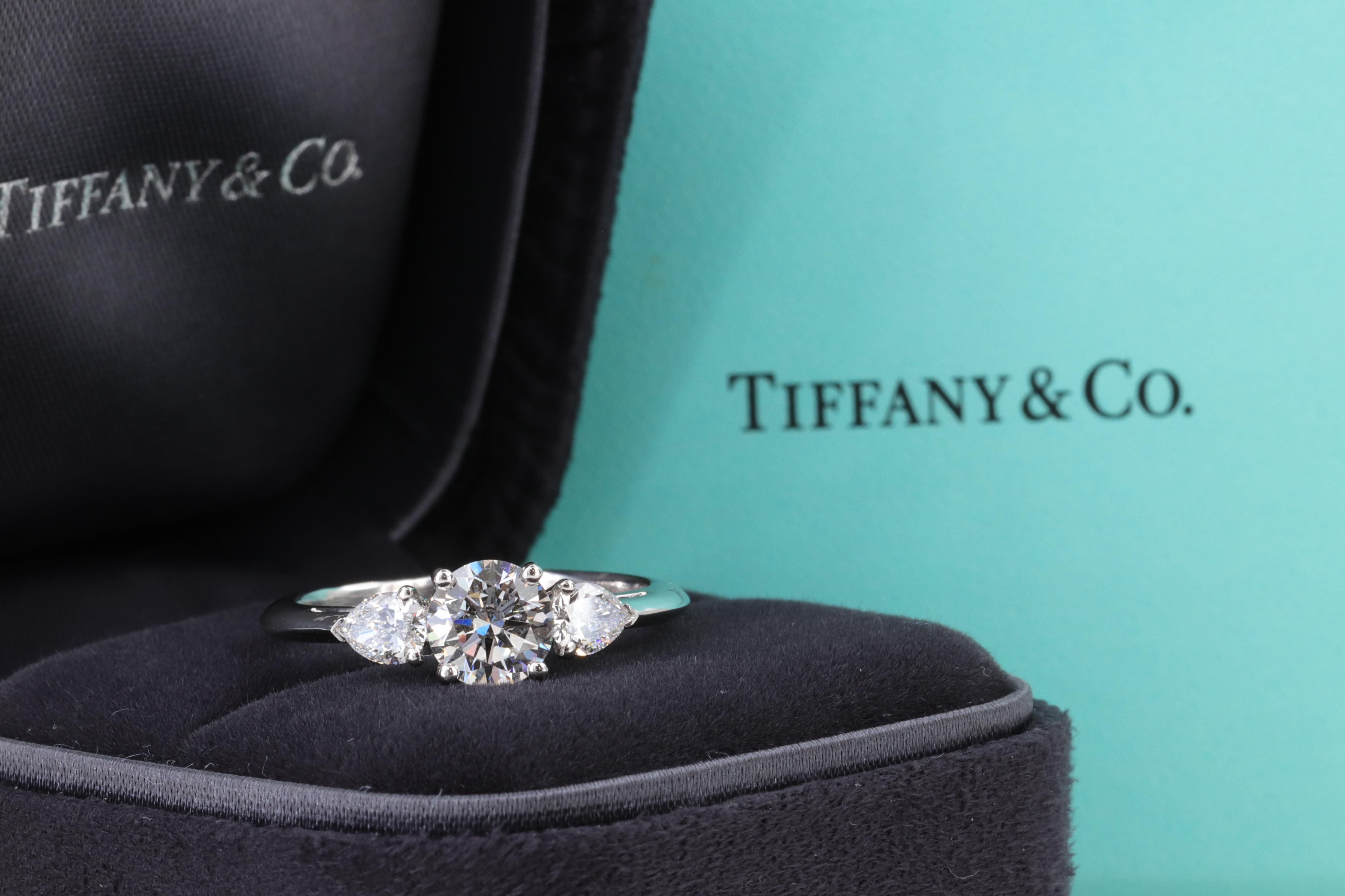 Tiffany & Co. Runder und birnenförmiger 3-Stein-Verlobungsring aus Platin

1.40 Karat Gesamtgewicht 
   
Mittelstein:
 
Gewicht - 0,96 Karat
Form - Runder Brillantschliff
Farbe - E
Klarheit - VS1
Abmessungen - 6,43 x 6,49 x 3,84 mm
Schnitt -