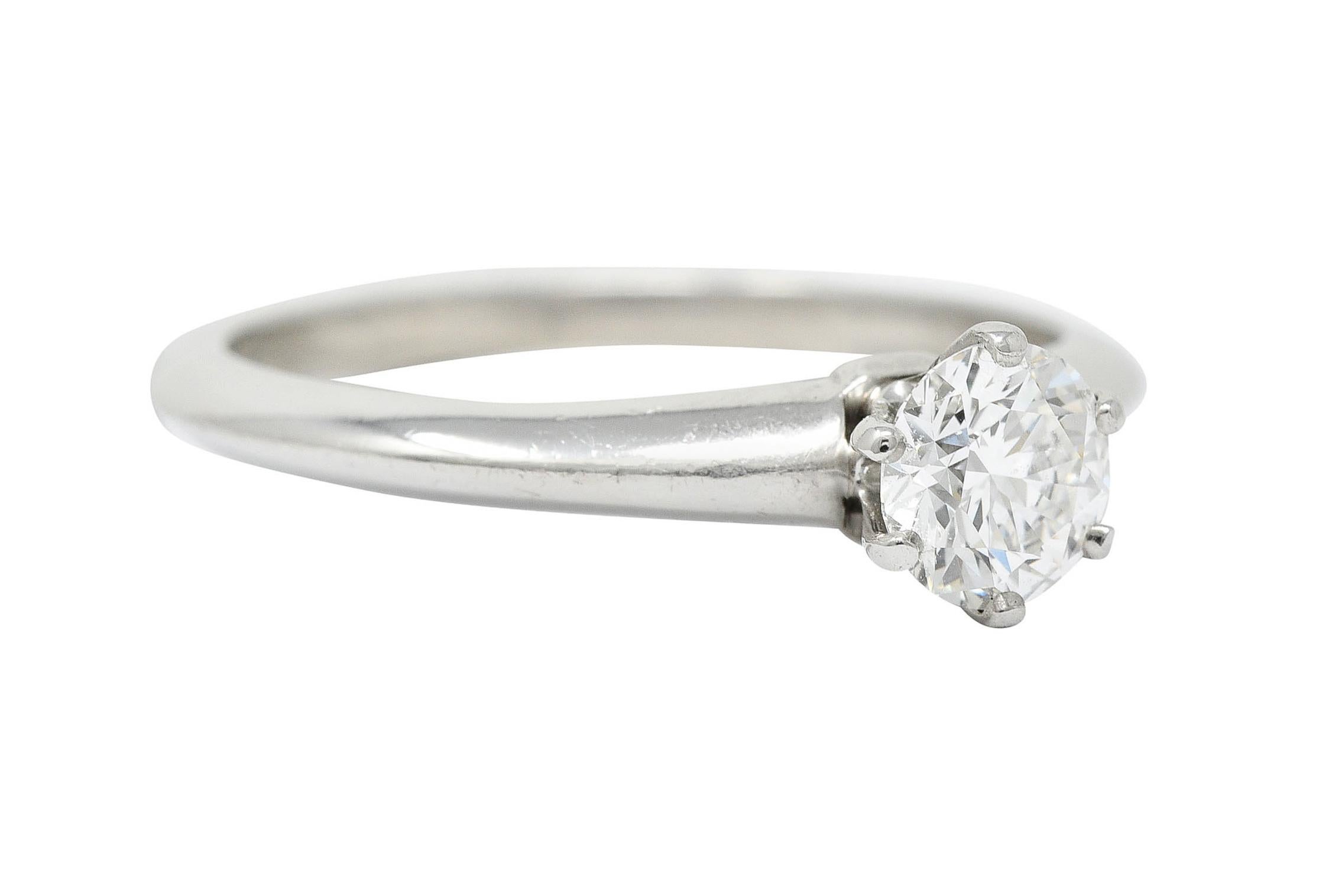 Centering a round brilliant cut diamond weighing 0.60 carat - H color and VS1 clarity

Set in a six pronged head of a solitaire style engagement ring

Completed by a subtle knife edged shank

Stamped PT950 for platinum

Numbered and fully signed