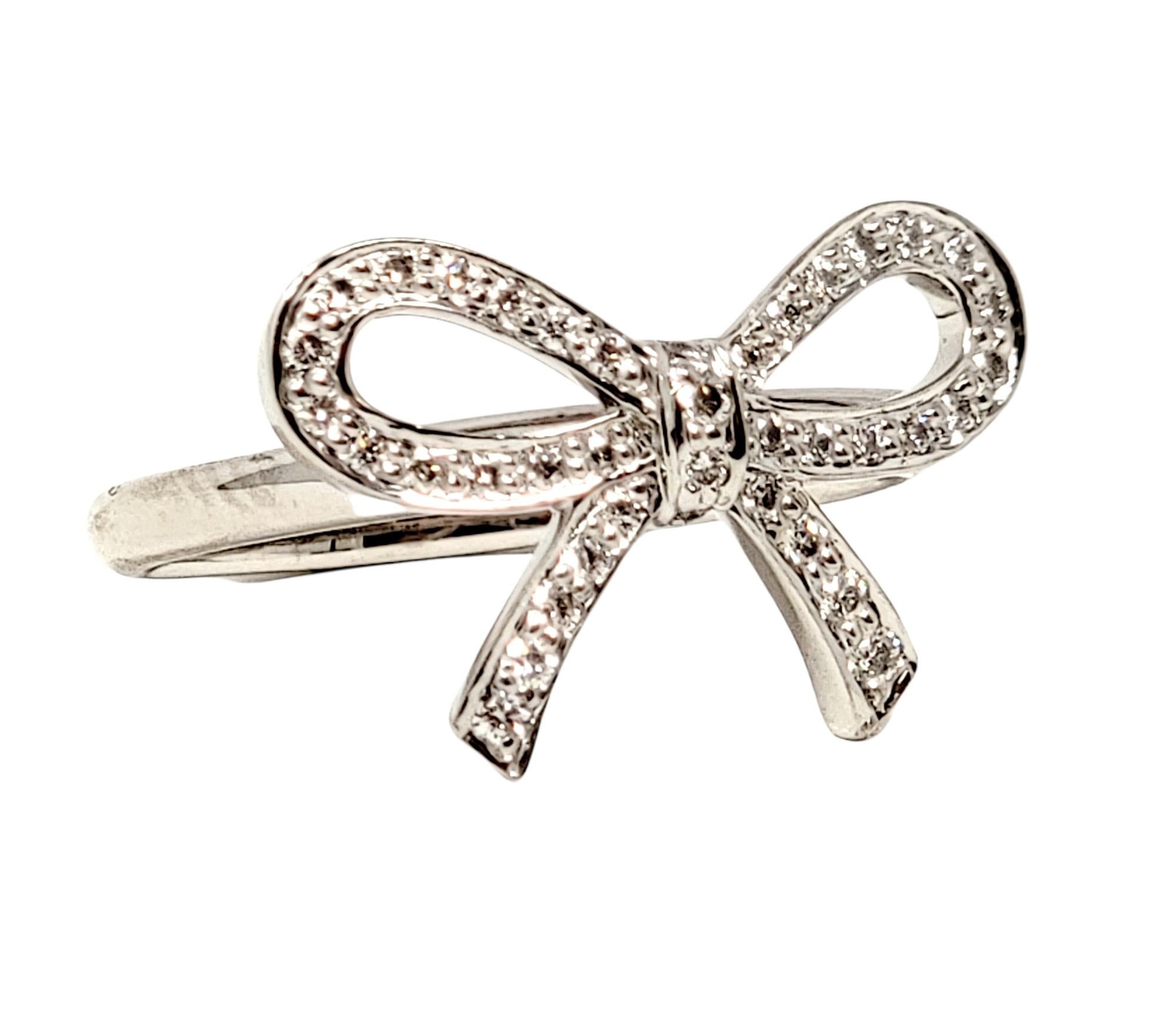 Ring size: 4.25

Absolutely lovely Tiffany & Co. diamond bow ring. This delicate, ultra feminine ring features a timeless design with understated elegance. The beautiful ring features a single bow motif arranged in a horizontal layout on a thin