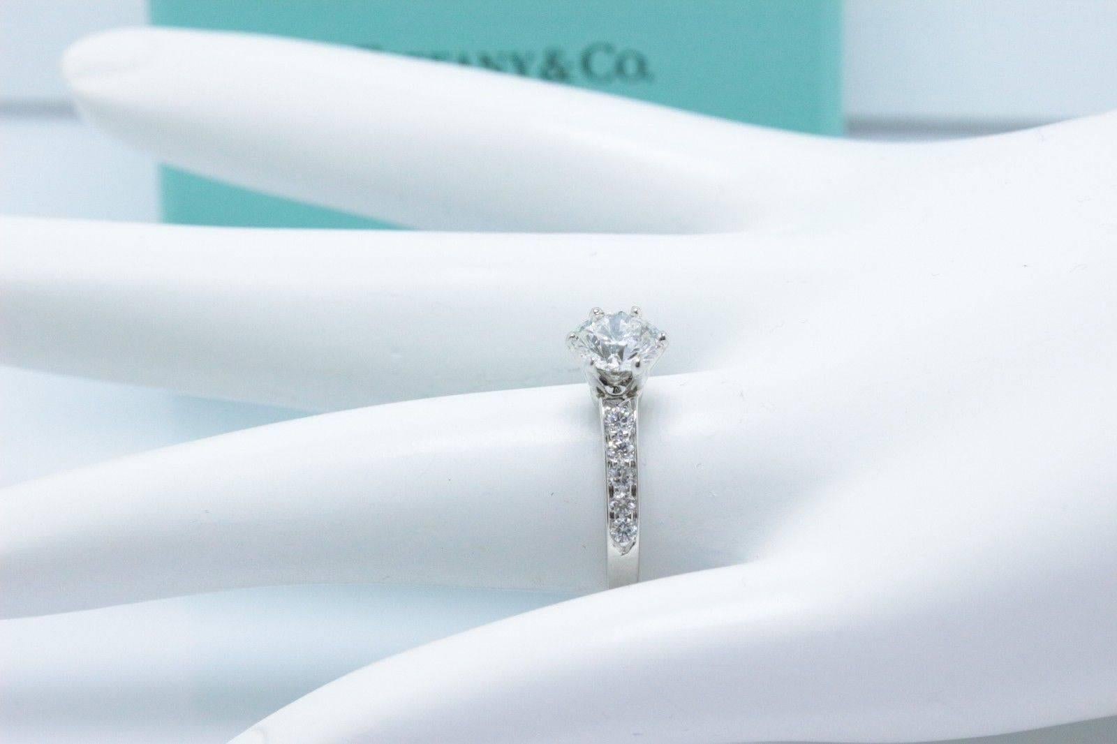 Tiffany & Co 
Bead Set Diamond Engagement Ring in Platinum.  
The Center Diamond is a Round Brilliant 1.00 CTS F color, VVS1 clarity.  
There are 10 Round Brilliant Diamonds Bead Set on the band of the ring... 0.27 TCW F color, VS1 clarity. 