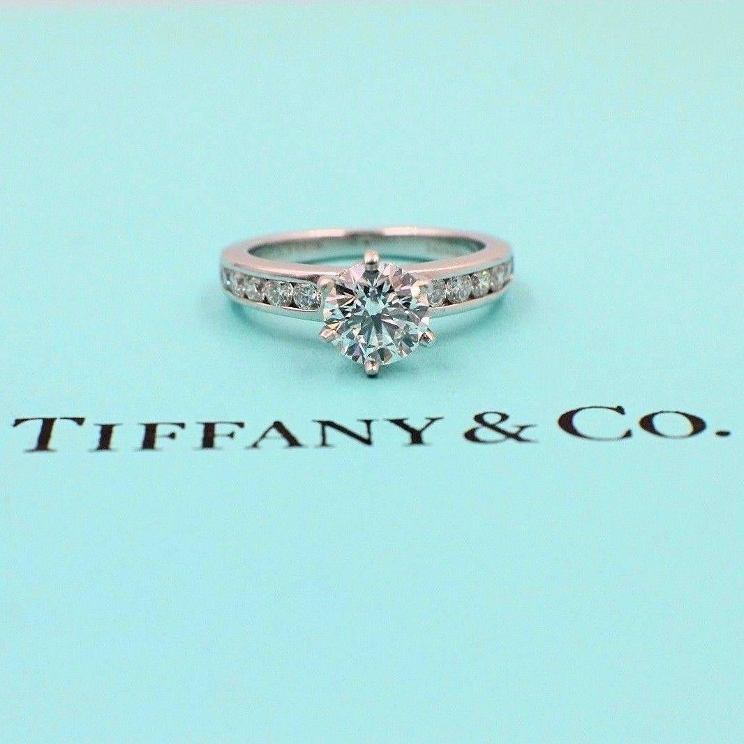 Tiffany & Co 
Six Prong Solitaire Engagement Ring with Channel Set Band.  
The Center Diamond is a Round Brilliant Cut 1.03 CTS F color, VVS2 clarity 
Inscription on a star facet of 