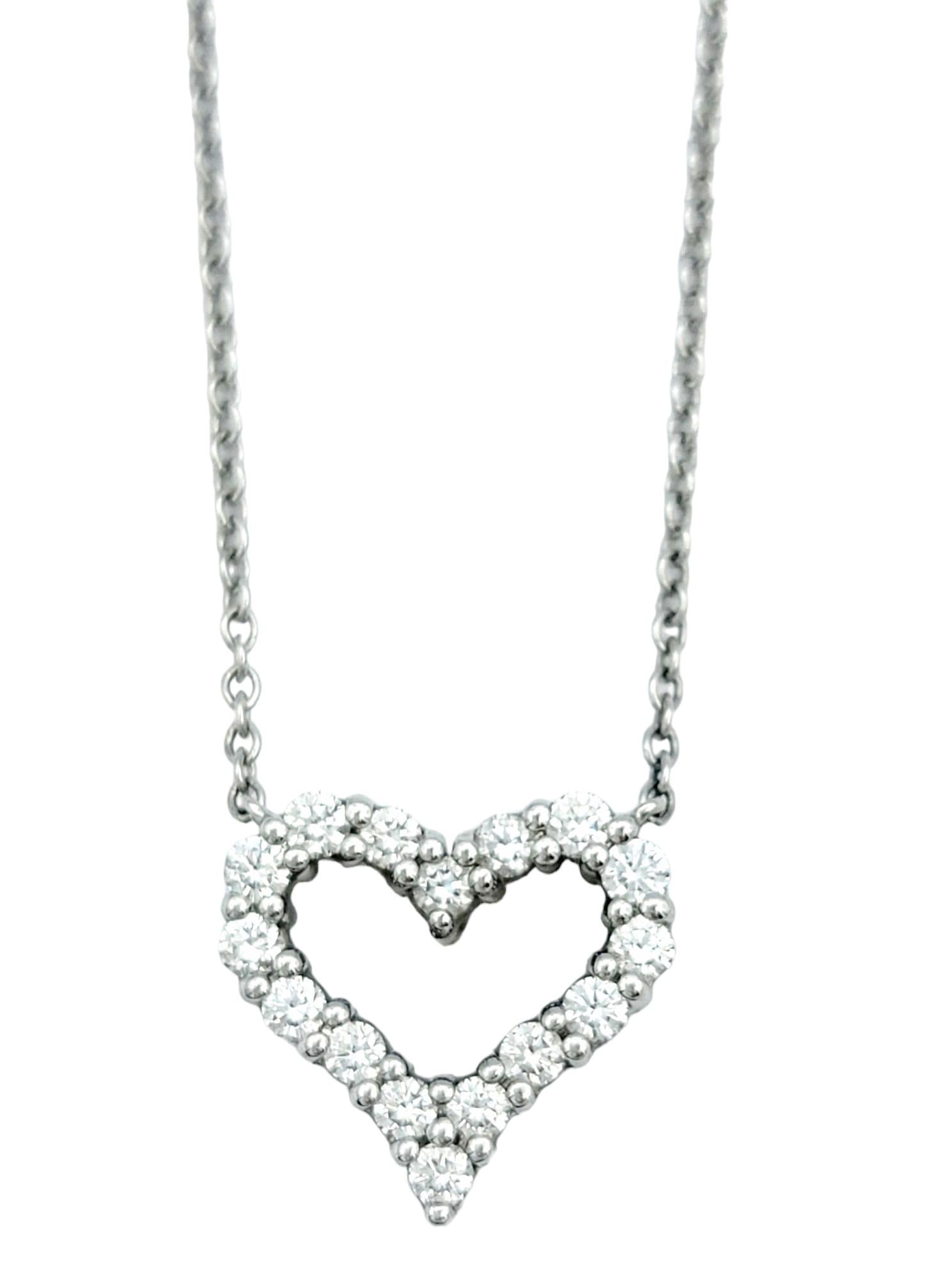 This petite Tiffany & Co. pendant necklace, set in polished platinum, is an embodiment of timeless elegance. The pendant takes the form of an open heart, adorned with a mesmerizing array of diamonds, adding a touch of brilliance to its delicate