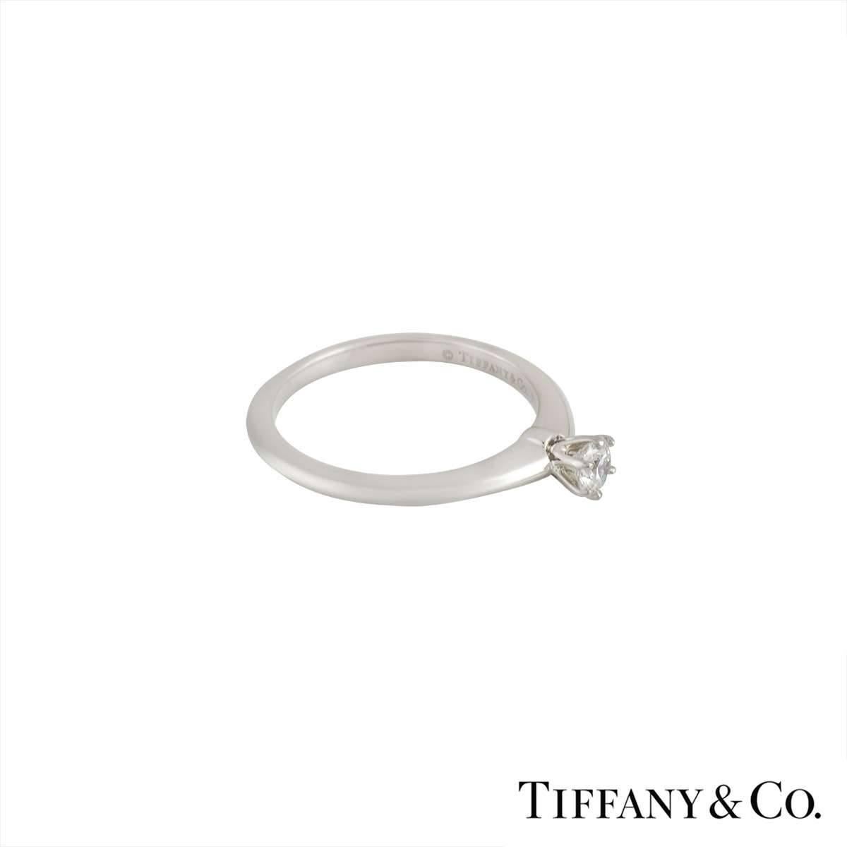 An elegant Tiffany & Co solitaire diamond ring in platinum. The ring is highly polished and features a classic knife edge design with an approximate 0.21ct diamond, colour G and a clarity of VS1 set in a 6 claw setting. The ring is currently a US